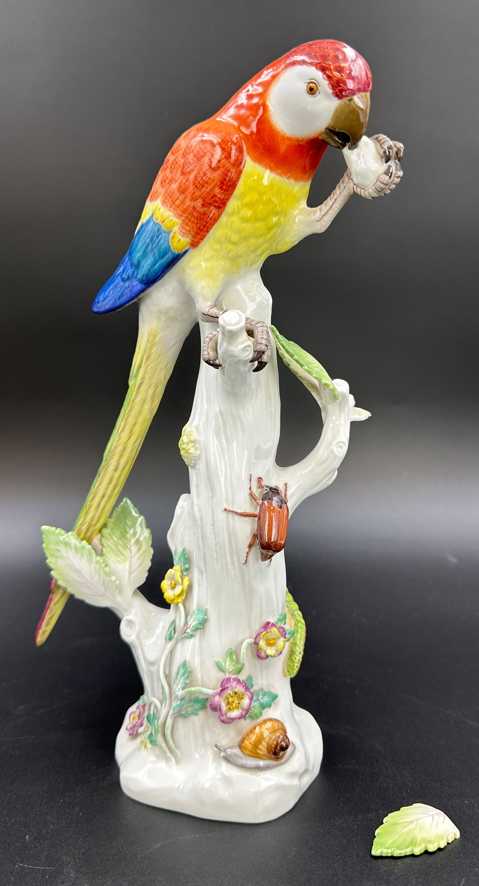 MEISSEN. Porcelain figurine. Parrot. 1st choice.: German Description: Circa 29 cm hoch. Porzellan. Unterseitig blaue Schwertermarke. Polychrom bemalt. Papagei auf stilisiertem Baumstamm sitzend. Reich verziert mit Blumendekor, Raupen, Käfer und Schn
