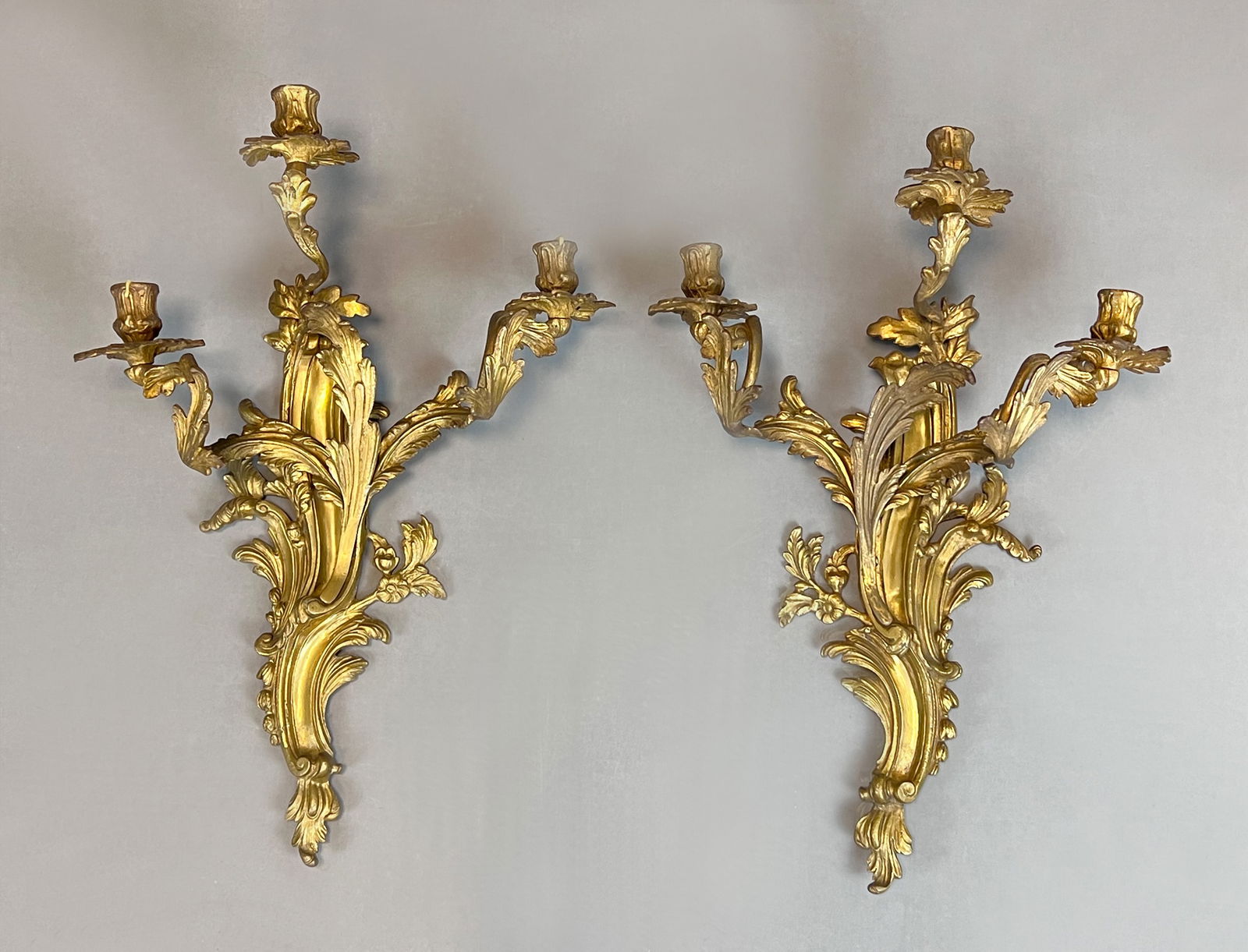 Pair of antique wall candlesticks. Gilt bronze. 19th century.: German Description: Jeweils circa 56 cm x 39 cm. Jeweils 3-flammig. Floral verziert mit Blätter- und Ranken-Dekor. Rückseitig mit Wandaufhängung. Guter Zustand in Anbetracht des Alters.