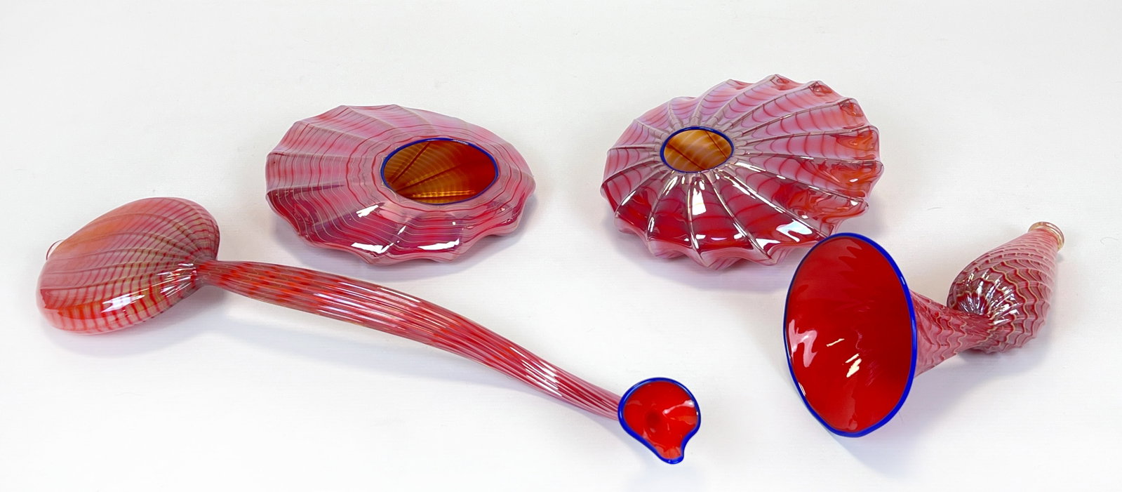 Dale Patrick CHIHULY (1941). 4 glass objects for "Cadmium Res Persian".: Ergänzungsstücke zu Vornummern. Circa bis 19 cm im Durchmesser. Circa bis 43 cm lang. Mundgeblasen. Korallenfarben mit Einschmelzungen und blauem Rand. Gewellte Formgebung. Keine Beschädigungen ode
