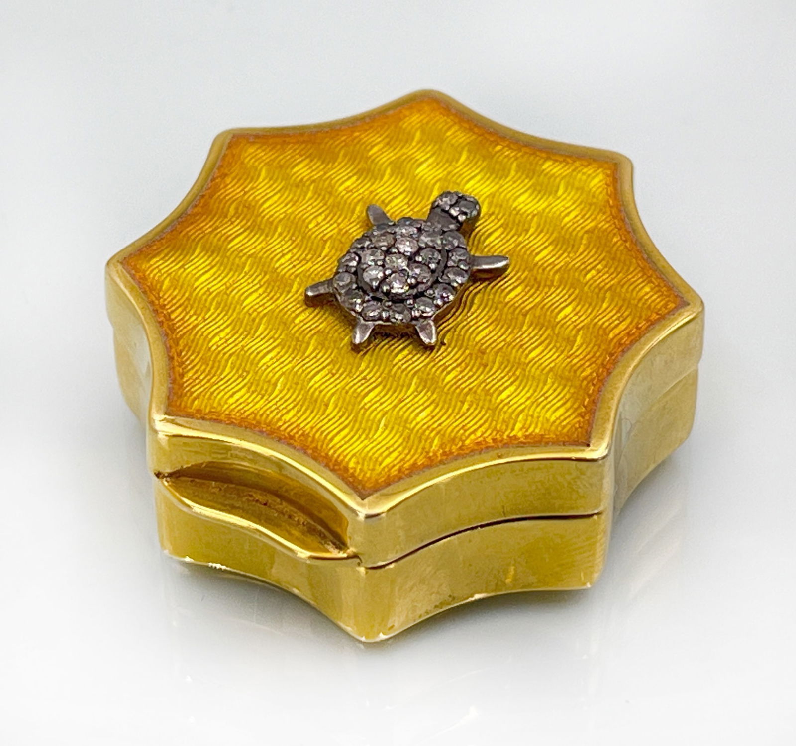 Enamelled pill box in the style of Peter Carl Fabergé. Silver. Russia. 20th century.: Circa 28,7 Gramm Gesamtgewicht. Circa 38 mm im Durchmesser. Silber vergoldet. Gewellter Rand. Deckel mit einer Schildkröte verziert. Diese ist mit insgesamt 26 sehr kleinen Diamanten besetzt. Gepunzt