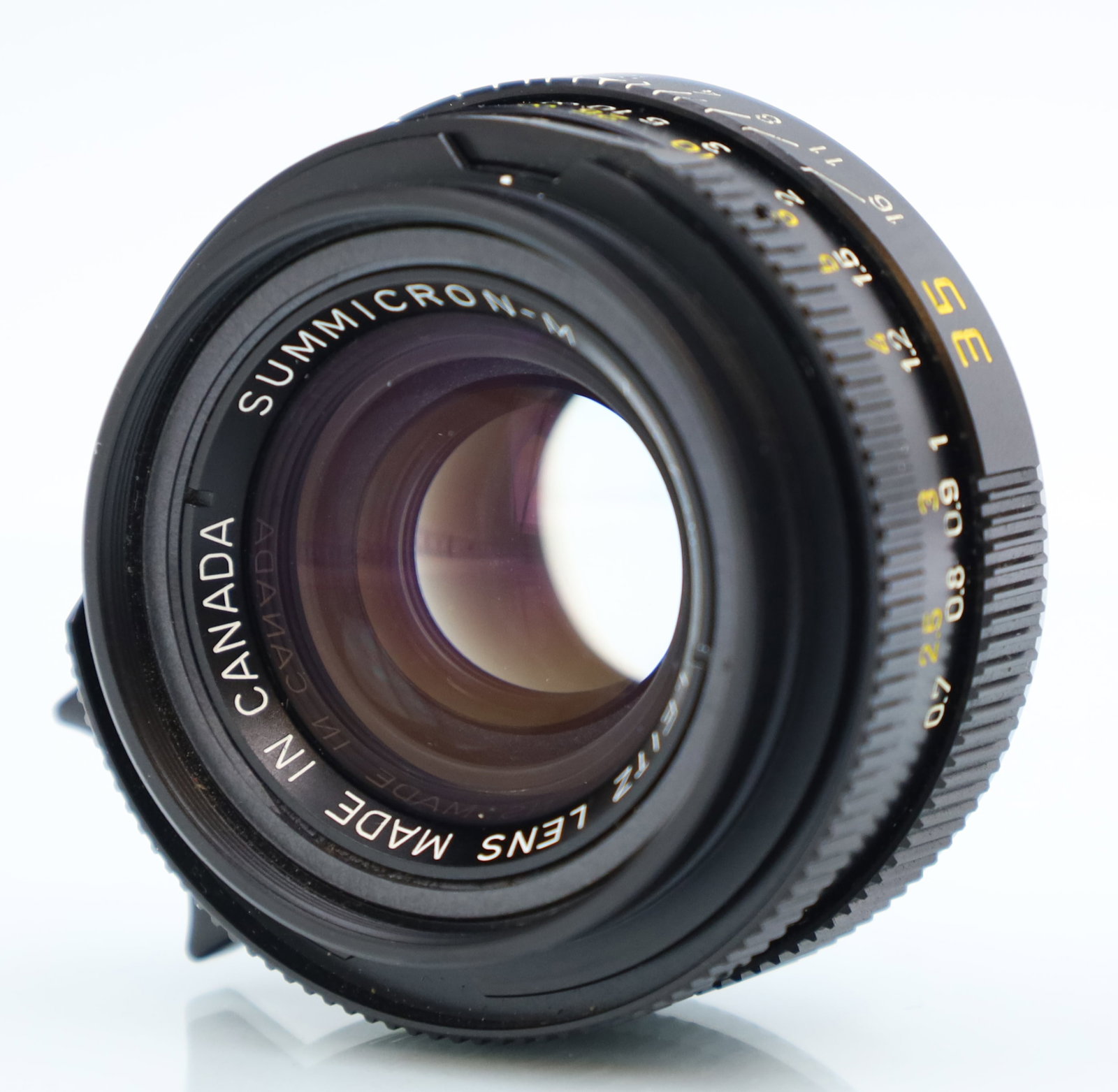 LEICA. Summicron-M. 1:2 / 35. Lens. M-Bajonett.: Circa 3,5 cm x 5,5 cm groß. Objektiv aus Metall. 35mm f/2. Leica M-Mount. Mechanik des Fokus- und Blendenrings geprüft. Inklusive Originalsonnenblende und Lederetui. Staubeinschlüsse. M