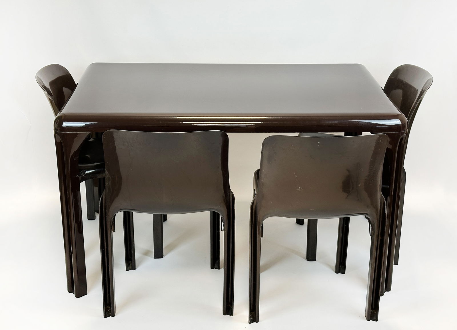 Vico MAGISTRETTI & Sergio MAZZA (XX - XXI). 4 Selene Stühle. 1 Stadio Tisch. ARTEMIDE. 1980er: 5Set of 5. Each of the 4 chairs measures 75 cm x 47 cm x 51 cm. Seat height approx. 42 cm. Dining table approx. 73 cm x 80 cm x 123 cm. Chestnut brown plastic. Designed by Vico Magistretti and Sergio