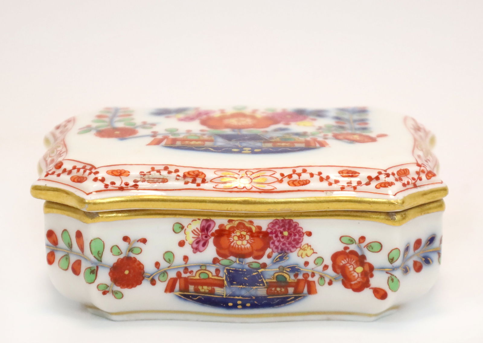 MEISSEN. Streichholzdose. Knaufzeit. 1. Wahl. Um 1900. MEISSEN. Matchbox. Knauf period. First: Approx. 3.5 cm x 9 cm x 7 cm. Porcelain. Underglaze blue sword mark. Polychrome painted. Gold decoration. Kakiemon-style table pattern. Rectangular shape with slightly bulbous, low walls and flat lid.