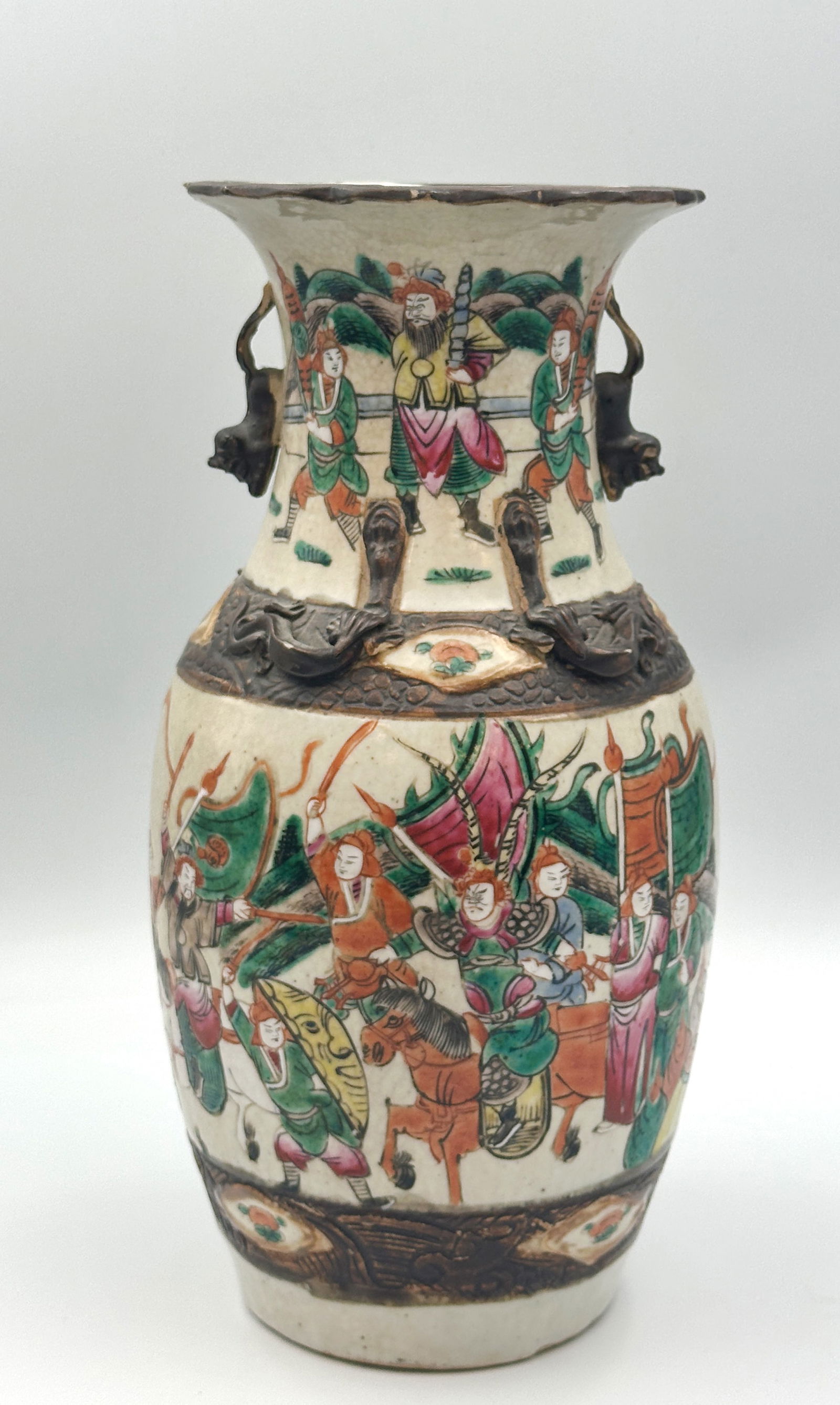 Nanking Vase. China. Anfang 20. Jahrhundert. Nanking vase. China. Early 20th century.: Approx. 35.5 cm high. Porcelain. Polychrome painted. Vase from Nanking. Amphora shape. Handles sculpted on the neck. Relief dragon figures on the shoulder. Multi-figure battle scenes on the wall. Seal