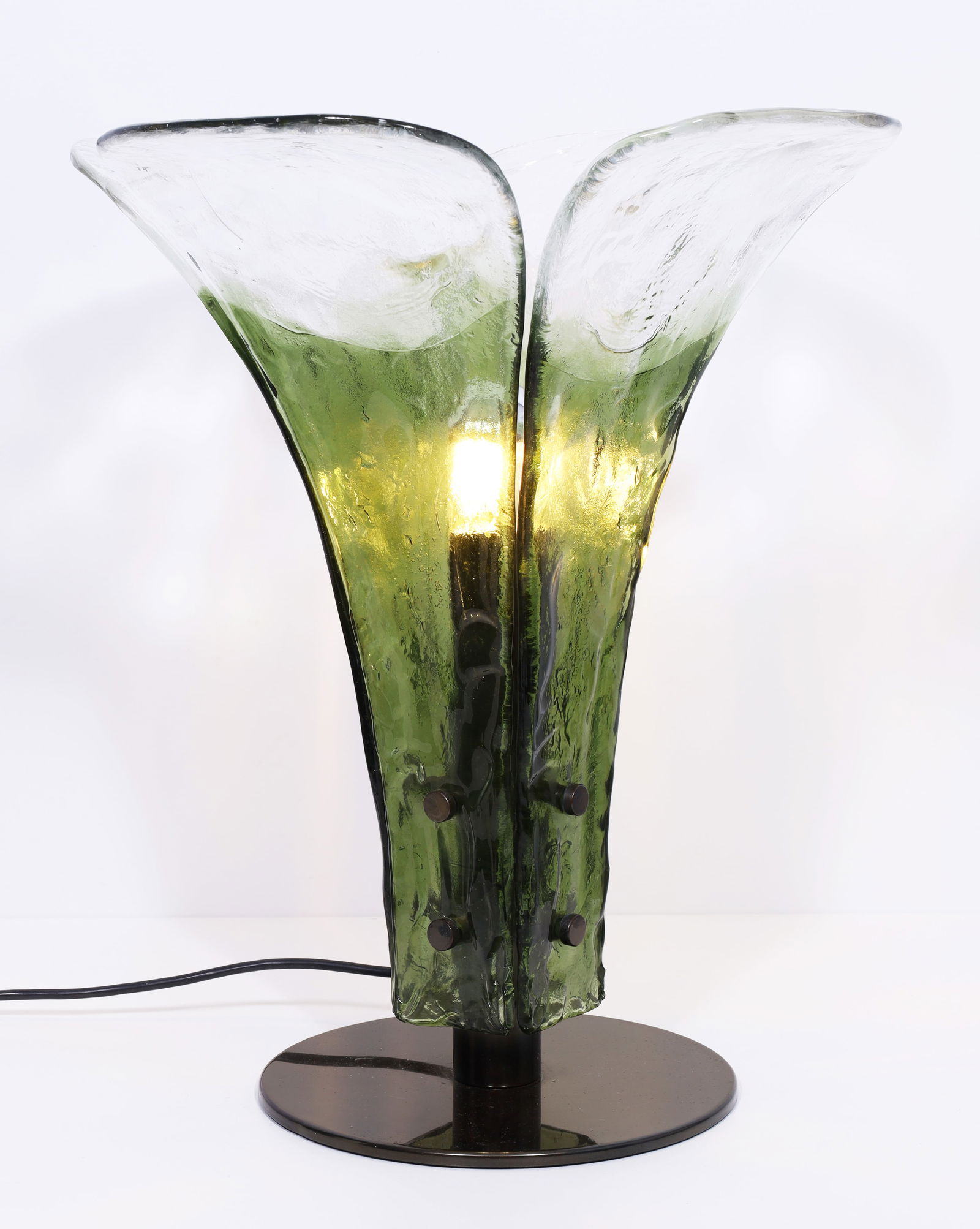 Carlo NASON (1935). Table lamp. Mazzega Murano. Italy. Approx. 49 cm high. Circa 1960.: Approx. 42.5 cm in diameter. Single-flame lampshade in the shape of a flower, made of four floral, green-tinted smoked glass elements with a textured surface on a round bronze-coloured base. Design: C