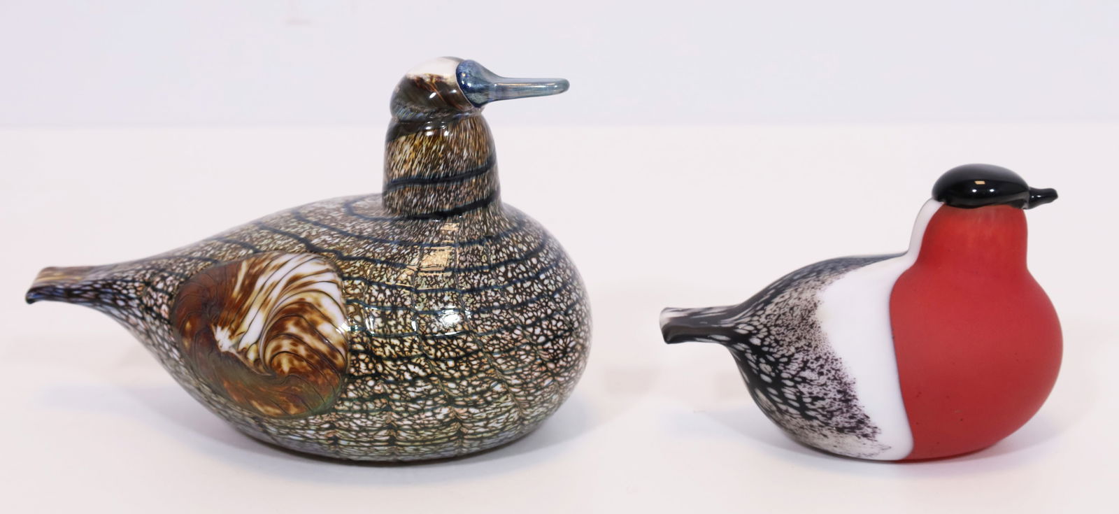 Oiva TOIKKA (1931 - 2019). 2 glass birds. ITTALA, Finland.: Approx. 11.5 cm x 17 cm for the large glass bird and 8.5 cm x 12 cm for the small glass bird. Glass objects made of polychrome glass, colourless overlay. Various decorations. Melted beak. Design: Oiva