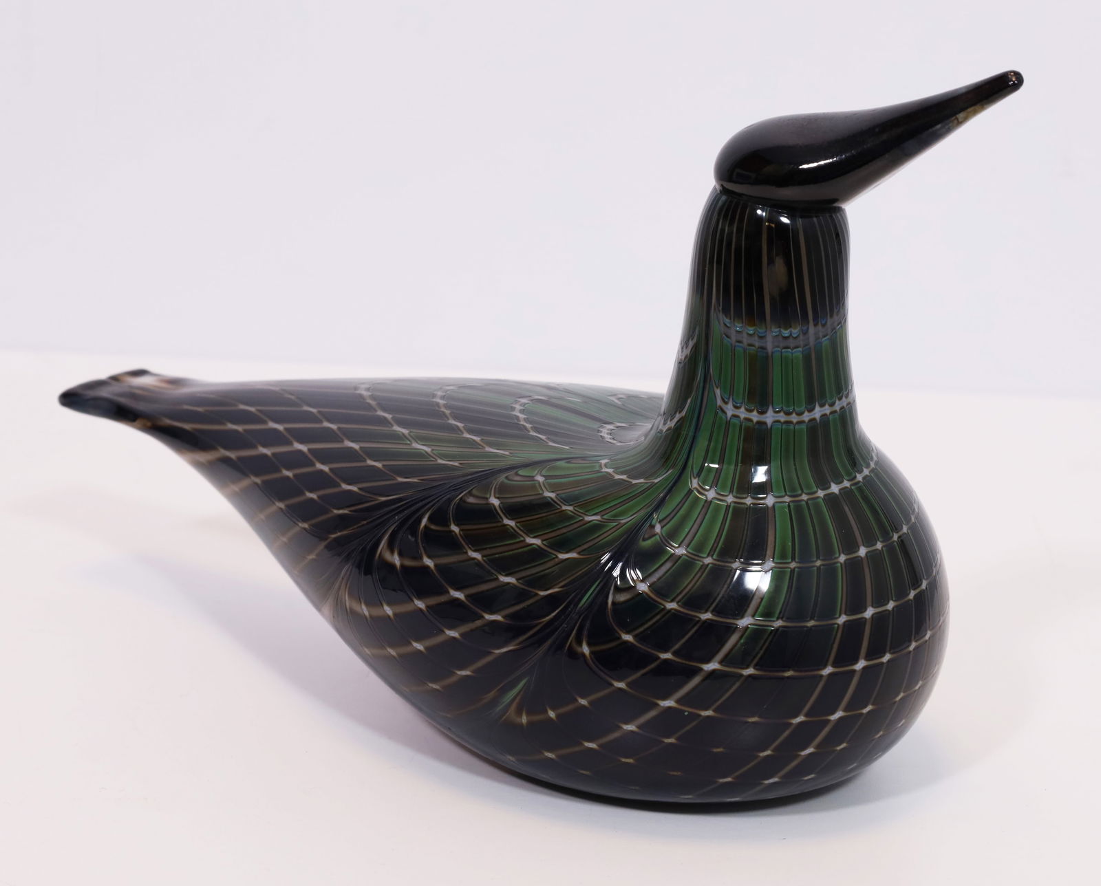 Oiva TOIKKA (1931 - 2019). Glass bird. ITTALA, Finland.: Approx. 20 cm x 32 cm. Glass bird made of opal green-brown-black glass, colourless overlay. Drawn comb decoration inside. Melted beak. Manufacturer's label on the underside, etched signature ‘O.