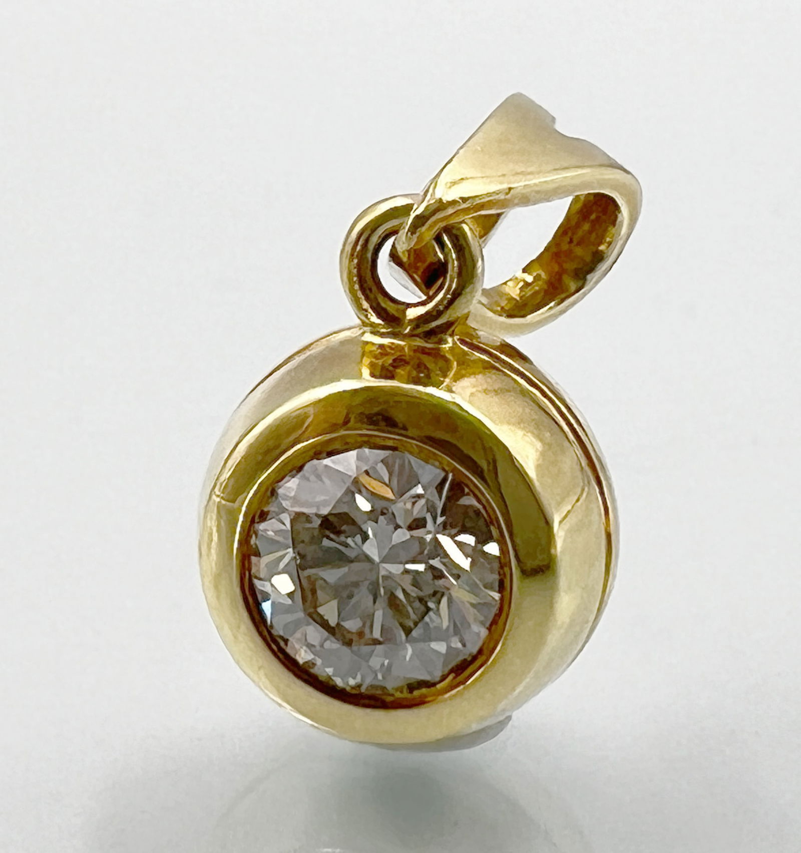Pendant. 750 yellow gold with a diamond of approximately 0.50 ct.: Approx. 4.2 grams total weight. Approx. 9 mm in diameter without eyelet. Brilliant cut approximately 0.50 ct. (5 mm x 5 mm x 3.3 mm) in high colour and medium clarity (SI1). Hallmarked. Gold tested. C