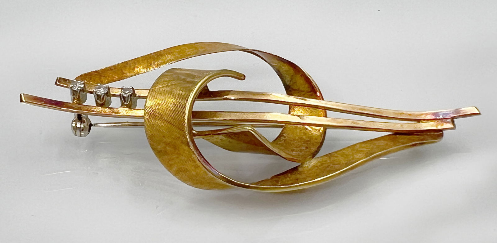 Brooch in stylised bow shape. 750 yellow gold with 3 very small diamonds. (1 of 5)