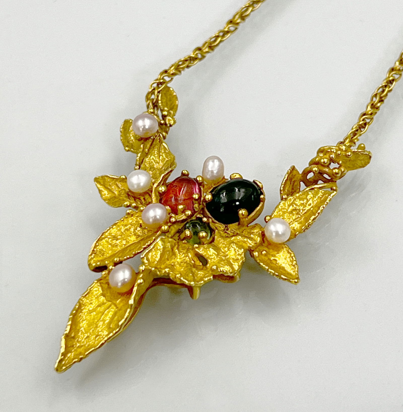 Necklace. ‘Magnificence’ 750 yellow gold with coloured stones and pearls. RENTMEISTER.: Total weight approx. 19.4 grams. Total length approximately 40 cm. Finely crafted foliage with green and red coloured stones and pearls as flowers. Surface partly matted, partly polished. Hallmarked g