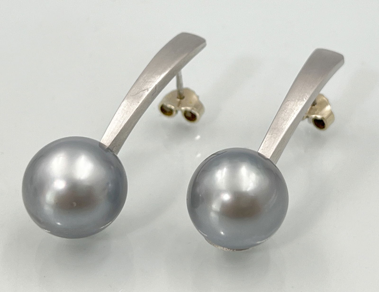 Pair of earrings. 750 white gold with Tahitian pearls.: Approx. 17.3 grams total weight. Total length approximately 41 mm. Rod-shaped, slightly convex curved pendants, each with 1 Tahitian pearl (approx. 14 mm diameter) Clasps made of 585 white gold (appro
