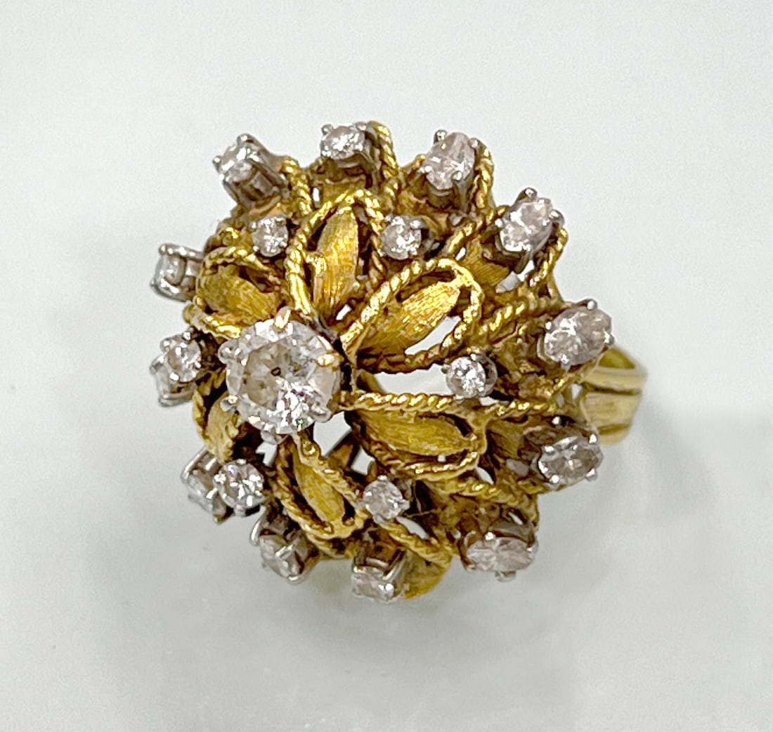 Cocktail ring. 750 yellow gold and white gold with diamond setting.: Approx. 16.8 grams total weight. Ring size: 54. Solid cocktail ring with sculptural floral detailing. Centred with a diamond of approx. 0.70 ct. Medium colour and low clarity. 18 smaller diamonds in v