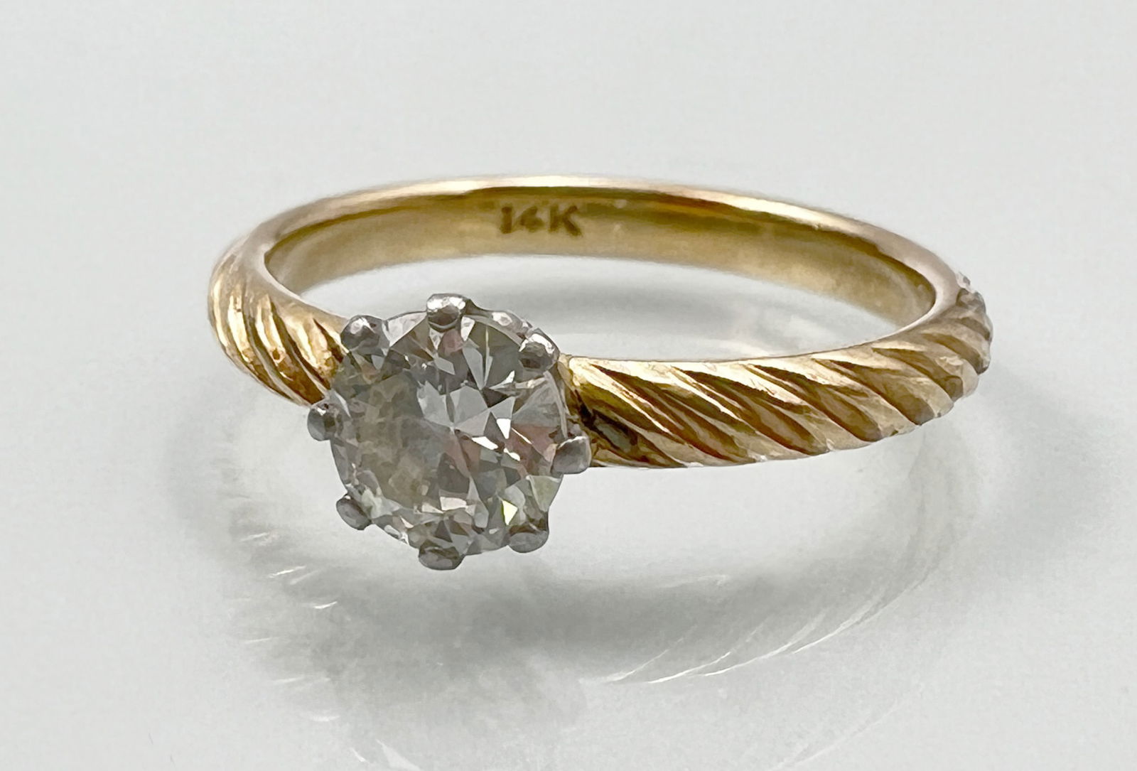 Solitaire ring. 585 yellow gold and white gold with diamond setting.: Total weight approx. 3 grams. Ring size: 55. Decorated ring band with 1 centre stone approx. 0.70 ct. High colour and medium clarity. White gold prong setting. Hallmarked: fineness. Gold tested. Condi