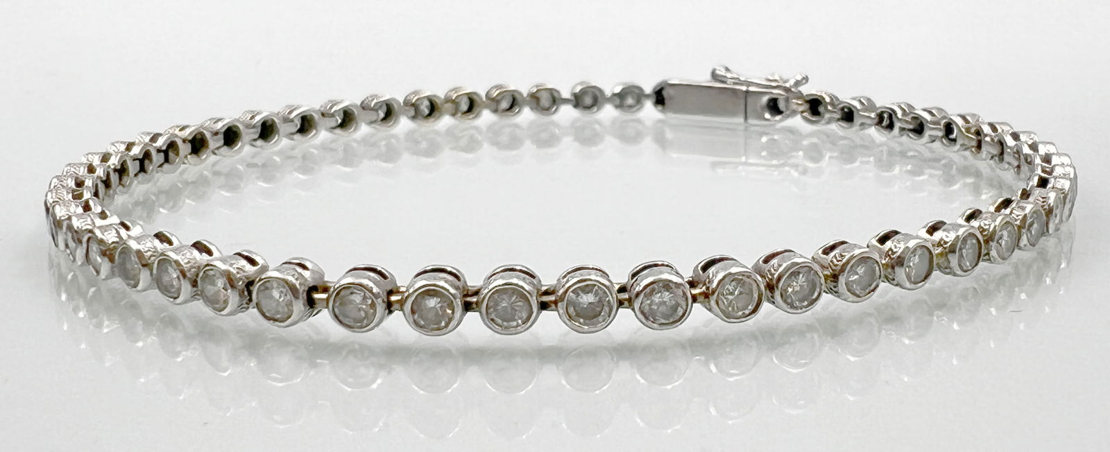 Tennis bracelet. 585 white gold with diamond setting.: Approx. 10.1 grams total weight. Approx. 20 cm total length when open. Set with 53 small diamonds totalling approx. 1.06 ct. in medium colour and clarity. Gold tested. Condition as shown in photos. Ca