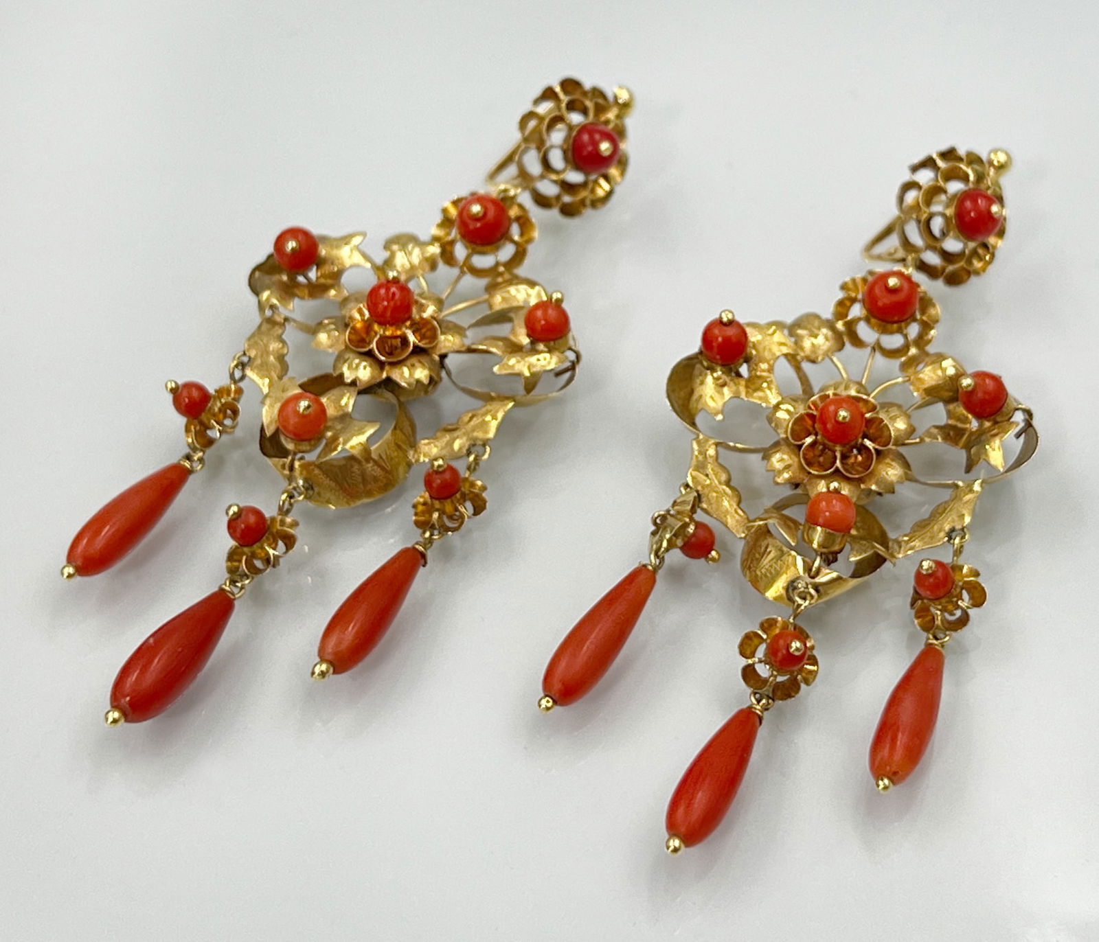 Pair of floral earrings. 750 yellow gold with coral trim.: Total weight approx. 16.8 grams. Exquisitely crafted floral drop earrings with spherical and cylindrical coral embellishments. Hallmarked: fineness. Gold tested. Condition as shown in photos. Category