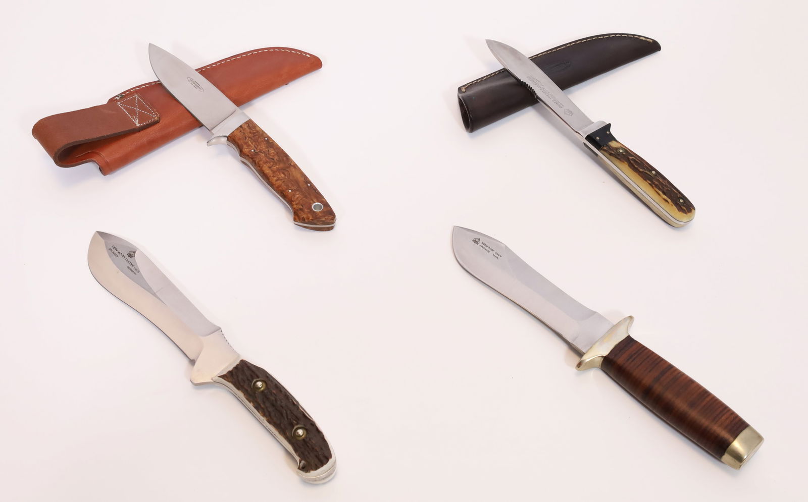 Set of 4 hunting knives. Mainly PUMA. Various designs.: From approx. 22.5 cm to approx. 27 cm total length. Manufacturers: 3 PUMA, 1 Peter Herbst. Handle scales made of wood, leather and horn. Various types of steel. Some with leather sheaths. Some unused