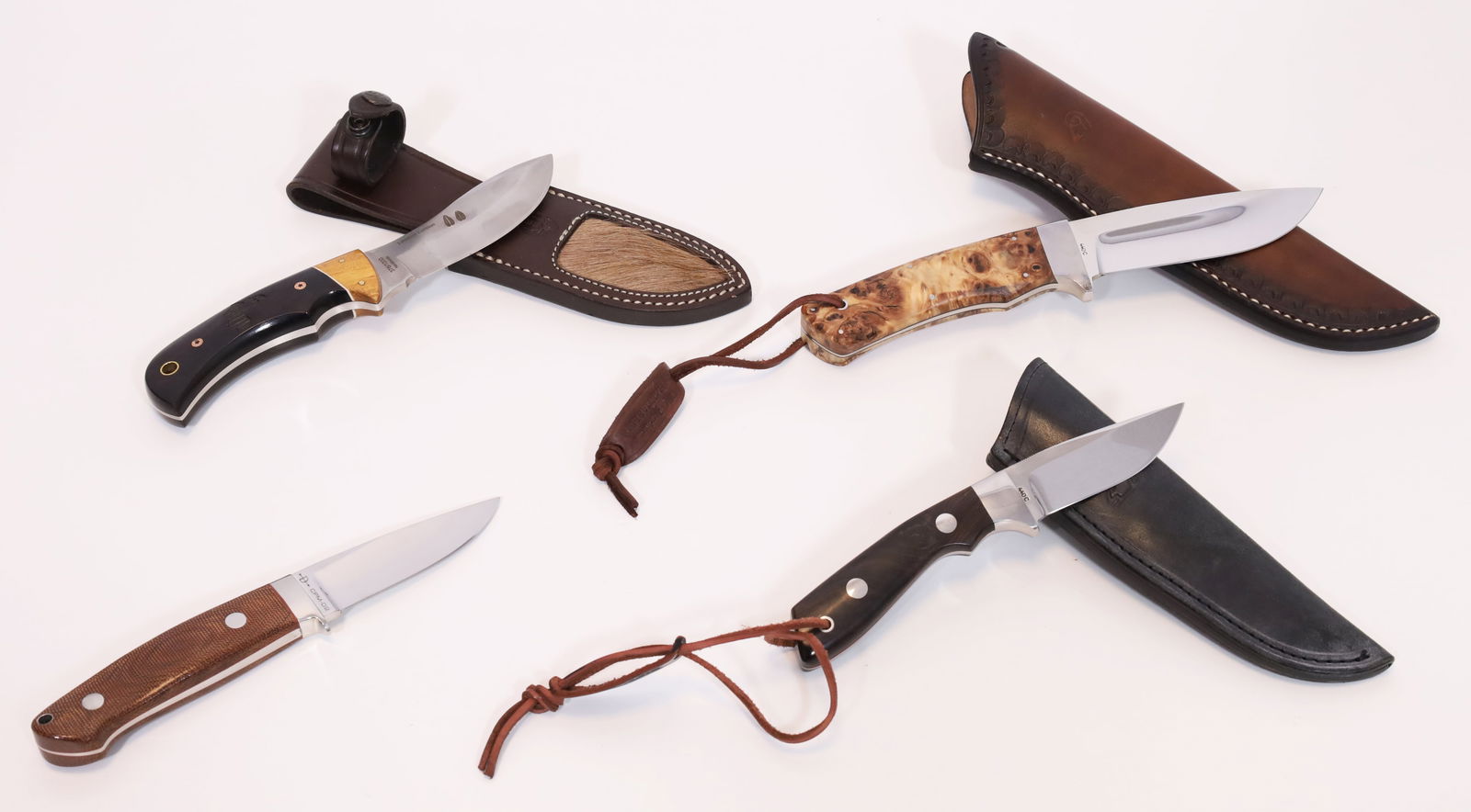 Set of 4 hunting knives. Various designs and manufacturers.: From approx. 19 cm to approx. 24 cm total length. Manufacturers: DNC, Böker and Muela. Handle scales made of wood and Micarta. Various types of steel. Some are limited editions, handmade and