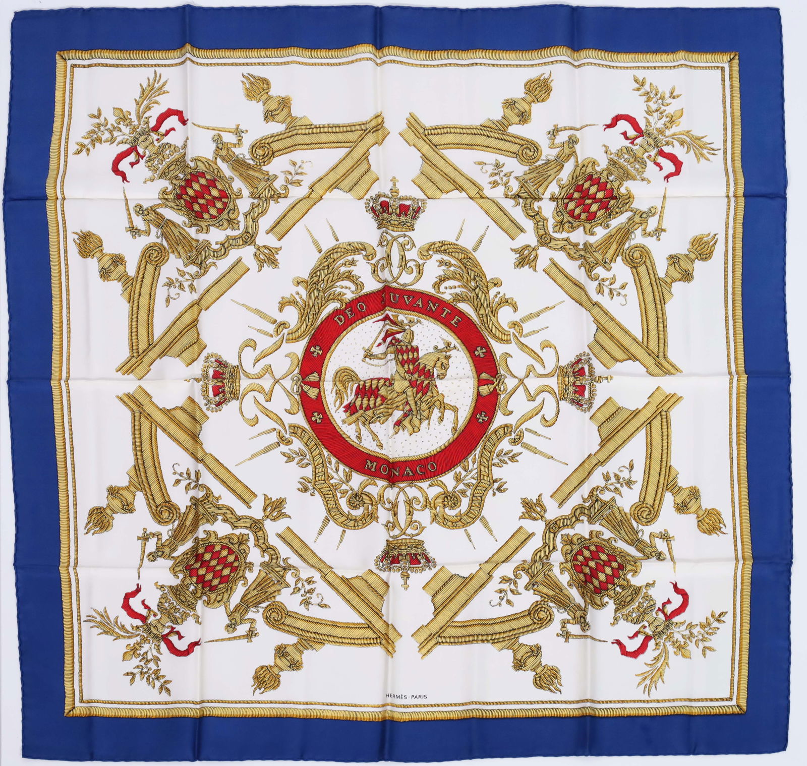 HERMÈS silk scarf. ‘Deo Juvante Monaco’.: Approx. 87 cm x 87 cm. Silk scarf in white, red, blue and black. ‘Deo Juvante Monaco’ motif by Hugo Grygkar. Good condition considering its age. See photos. Category: Vintage / Fashion /