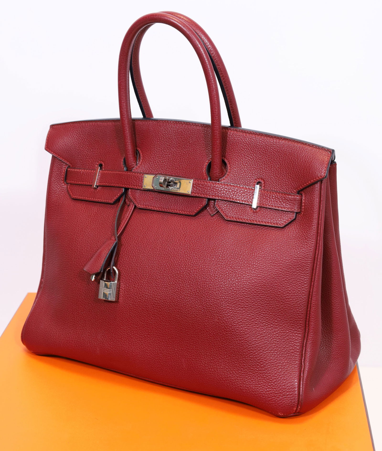 HERMÈS Birkin Bag / Handbag 35. Bordeaux red. Togo. 2000.: Approx. 35 cm x 28 cm x 19 cm. Calfskin handbag in burgundy red. Palladium-coloured hardware. Double handles. Includes lock, key and clochette. Two interior pockets, one with zip and one without. Blin