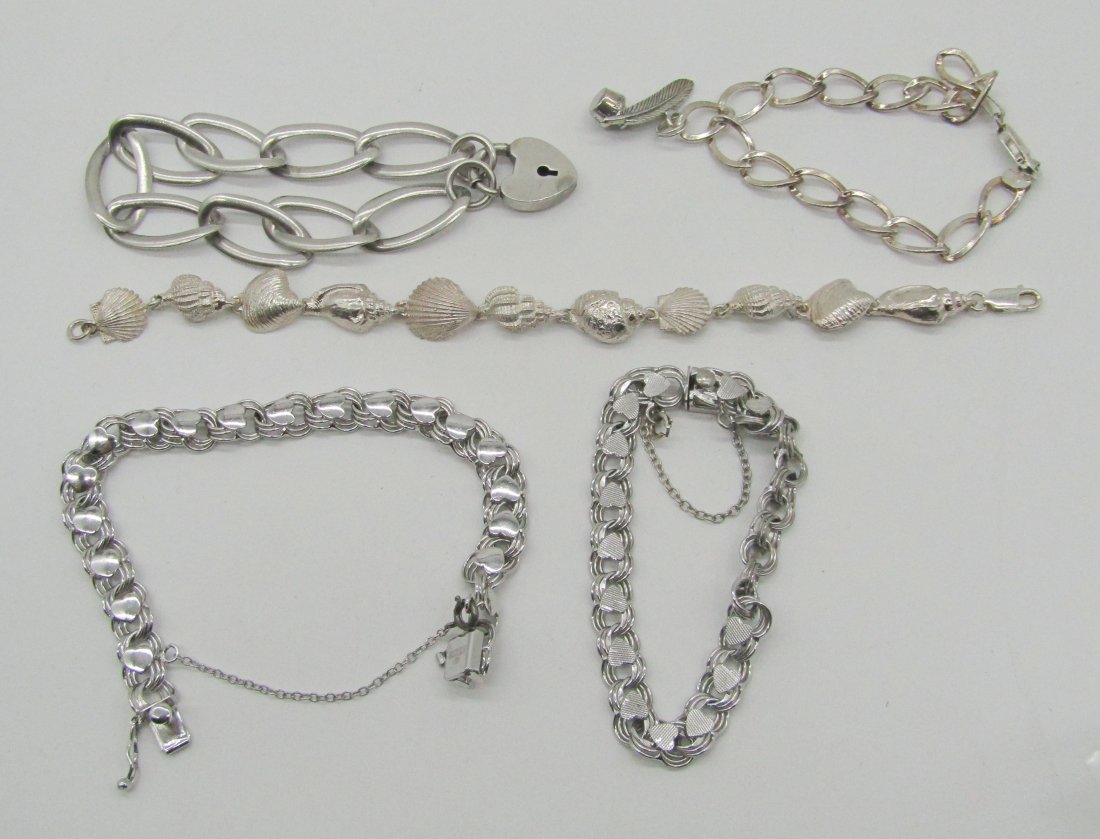 estate lot of sterling bracelets: to include charm bracelets, love bracelet, etc. weighs 67.5 grams.