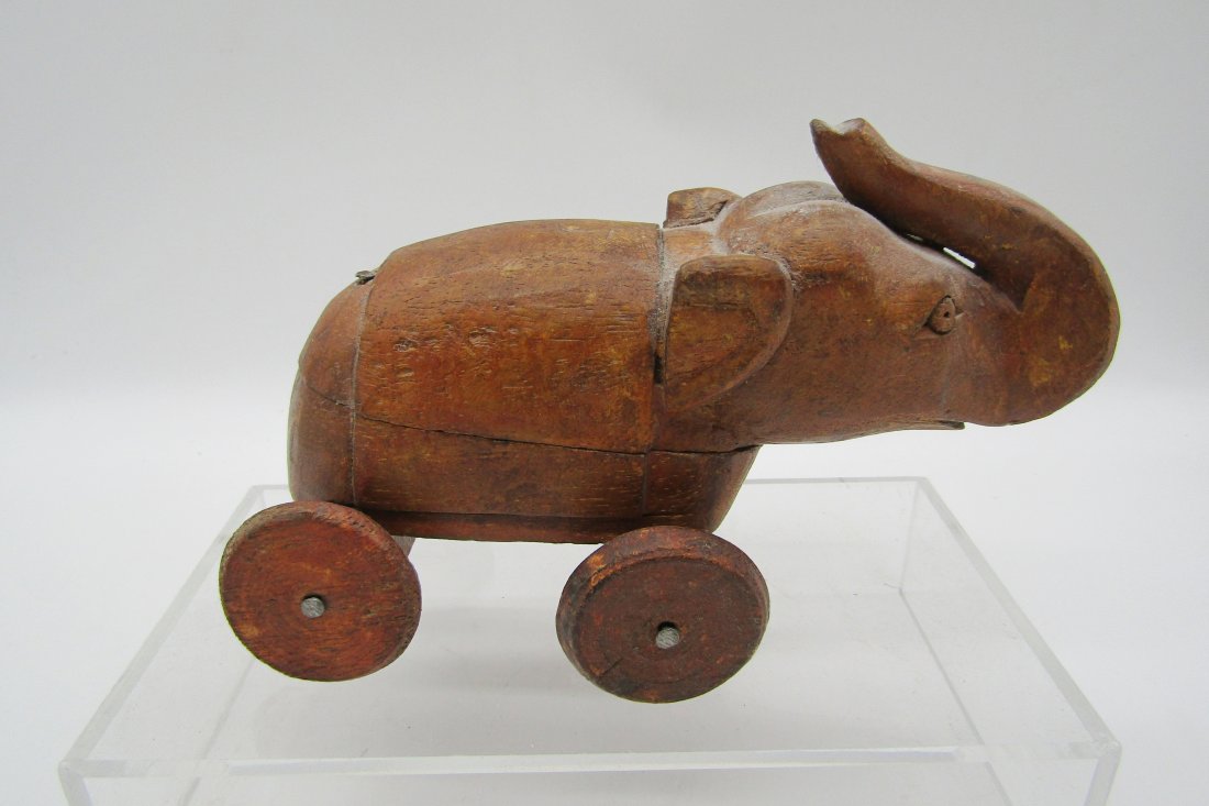 hand carved Wood Elephant toy on wheels: hand made wood Elephant toy on wheels. measures 8" long. body slides open to reveal compartment.