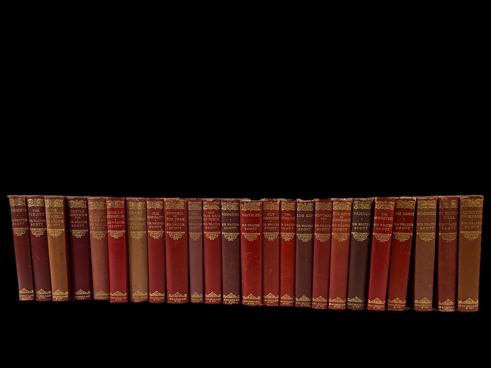 24 Mixed Volumes of The Waverley Novels by Sir Walter Scott: 24 Mixed Volumes of The Waverley Novels by Sir Walter Scott, Dates range from 1912-1932, Red leather bindings with gold gilt on spine, Condition good, has shelf wear, rubbing, small tears, bumped