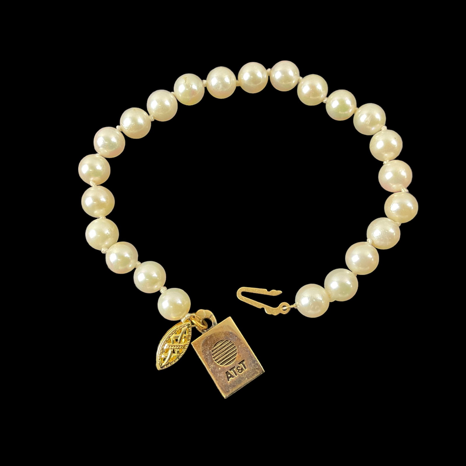 6.2 mm Pearl Bracelet with 10K Charm & 14k Clasp: 6.2 mm Pearl Bracelet with 10K Charm (AT&T) & 14K Clasp Bracelet Measures: 7.25” L Weight: 10.8 g Condition: Very Good, See Photographs 