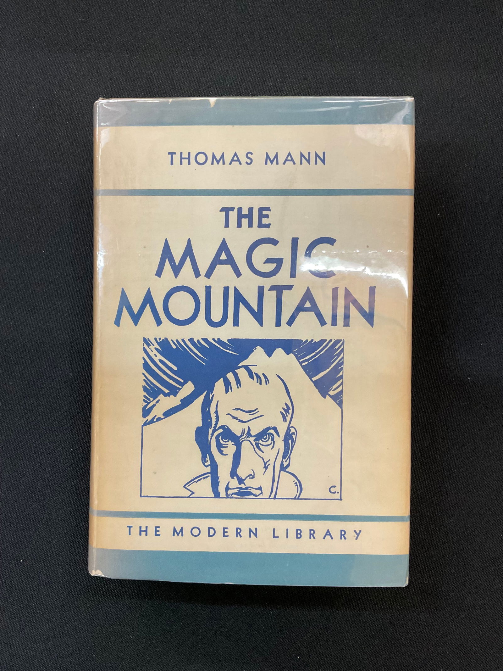 The Magic Mountain by Thomas Mann 1927: The Magic Mountain by Thomas Mann 1927 Modern Library Edition, Translated by H. T. Lowe-Porter Dust Jacket and Mylar Cover, Condition book bumped corners and faded, DJ small tears and faded, see photo