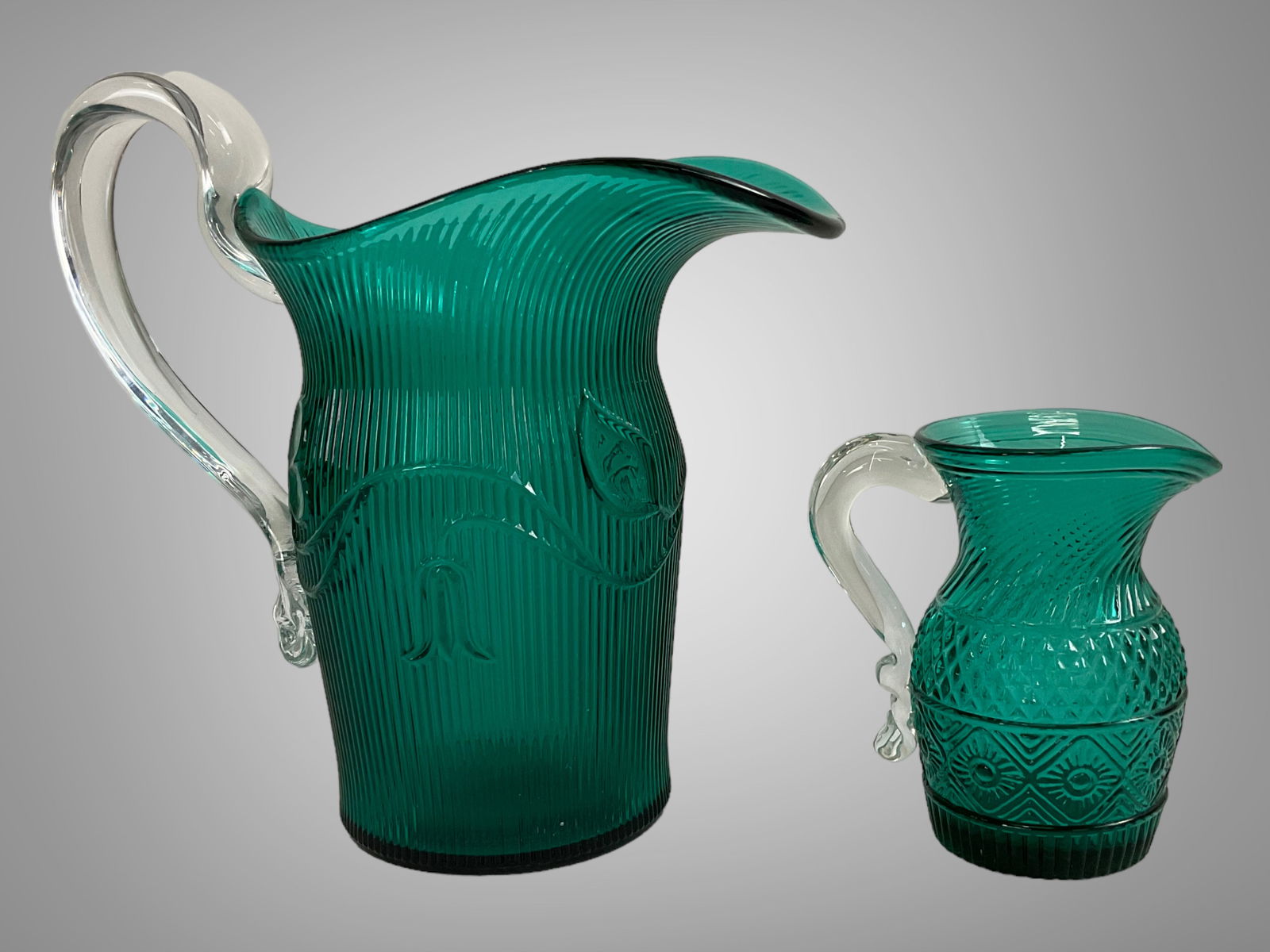 2 Metropolitan Museum of Art Green Glass Pitchers: 2 Metropolitan Museum of Art Green Glass Pitchers, Two green glass pitchers from the Metropolitan Museum of Art, The hand blown Pilgrim glass pitcher measures 4.25" tall and was made