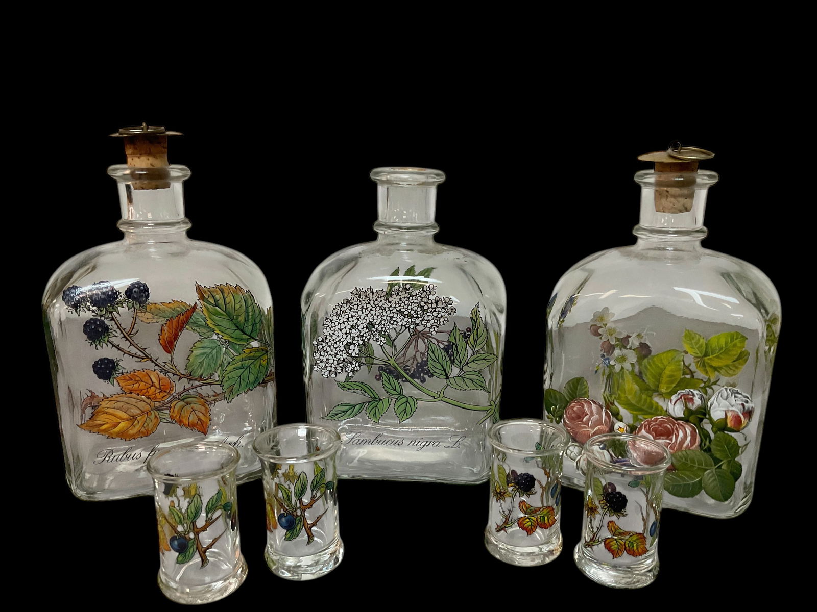 Group of 7 Holmegaard Floral Glass Bottles and Glasses: 7 Holmegaard Floral Glass Bottles, 3 Holmegaard Painted Floral Glass Bottles/Decanters, 6 1/2" tall,4 1/4" wide, 3" deep, only 2 cork tops, 4 Holmegaard Painted Floral Shot Glasses/Toot