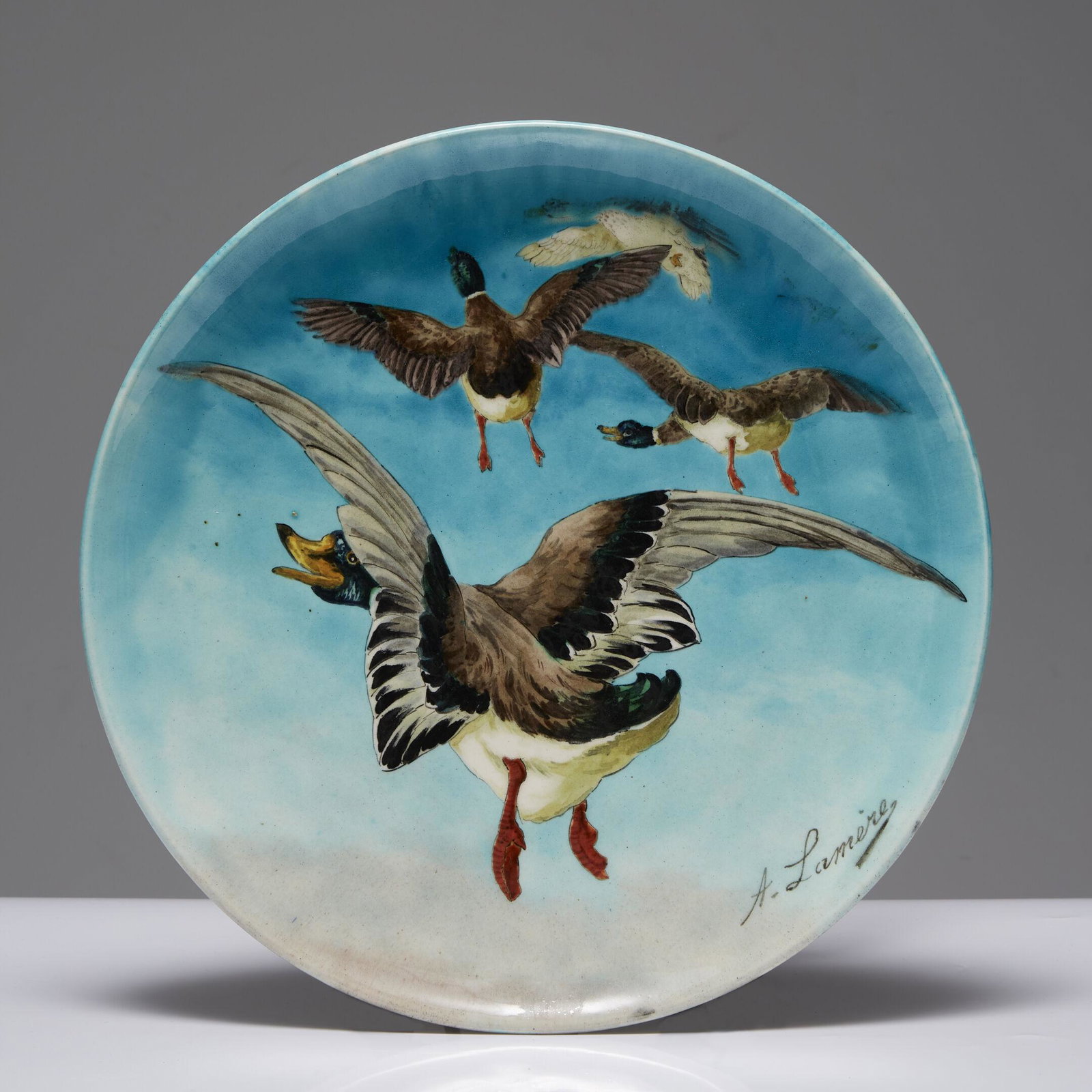 A. LAMÈRE & THEODORE DECK ATELIERS (ATTRIBUÉ A) Suite de deux plats circulaires en faï: A. LAMÈRE & THEODORE DECK ATELIERS (ATTRIBUÉ A) Suite de deux plats circulaires en faïence à décor de vols de canards, émaux polychromes sur fond turquoise en dégrad