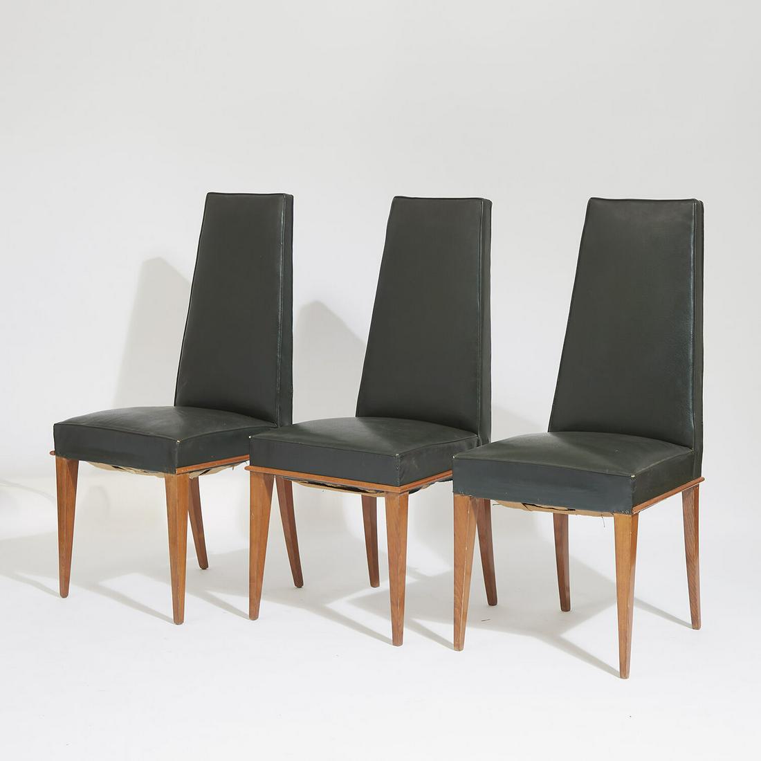 DOMINIQUE (DANS LE GOÛT): DOMINIQUE (DANS LE GOÛT) Suite de six chaises à haut dossier trapézoïdale en noyer verni entièrement recouvert de skaï vert sapin. Piètement gaine à l'avant, sa