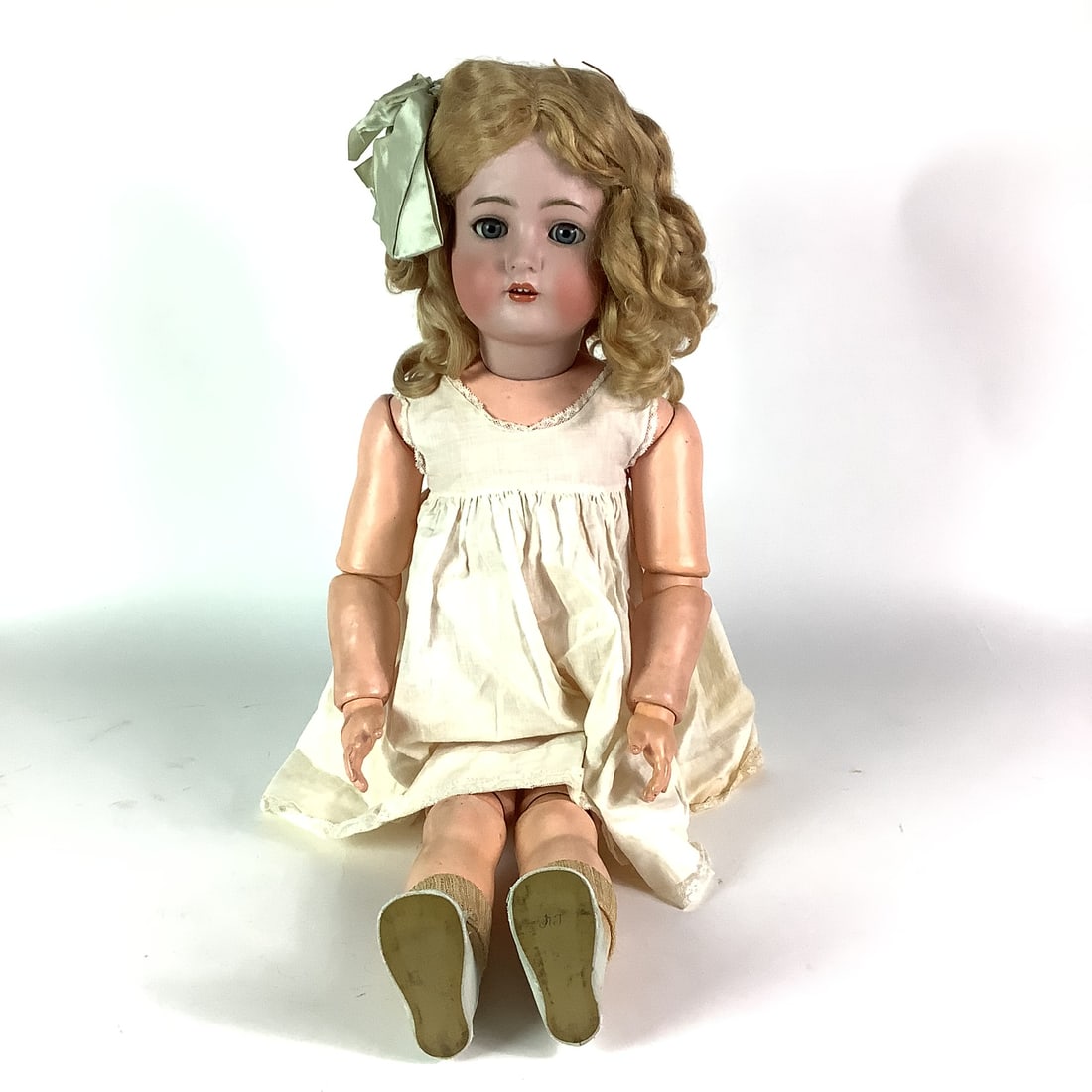 Simon & Halbig 28" Antique Bisque Doll Head #70: Dressed with additional clothing, flirty eyes, with teeth. Only noticeable damage is on her right shoulder, has piece chipped off. Stands 28" high