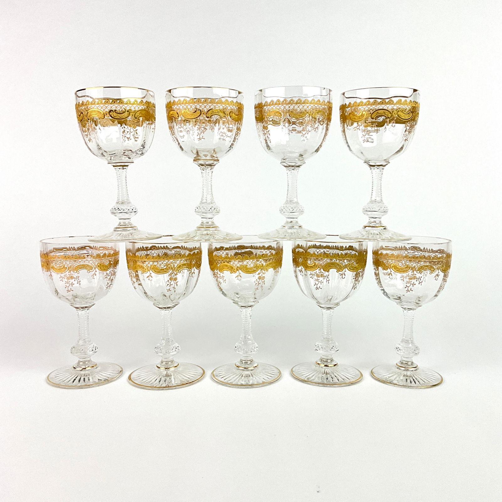 9 Saint Louis Massenet Wine Glasses: 9 Saint Louis Massenet clear gold encrusted wine glasses. gold encrusted folate and floral design to bowls with gilt accents, cut glass knobbed stem, with a star cut foot.Measurements: 4.75" in height