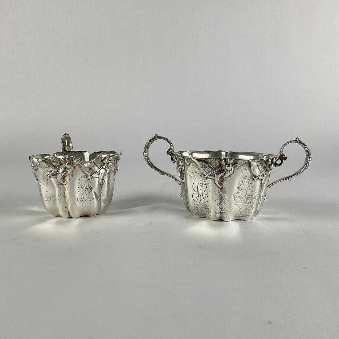 Sterling Floral/Berries Sugar & Creamer: Hall-marked, 7.7 oz. Sugar: 2" high x 3.5" diameter. Creamer: 2" high x 2.75" diameter.