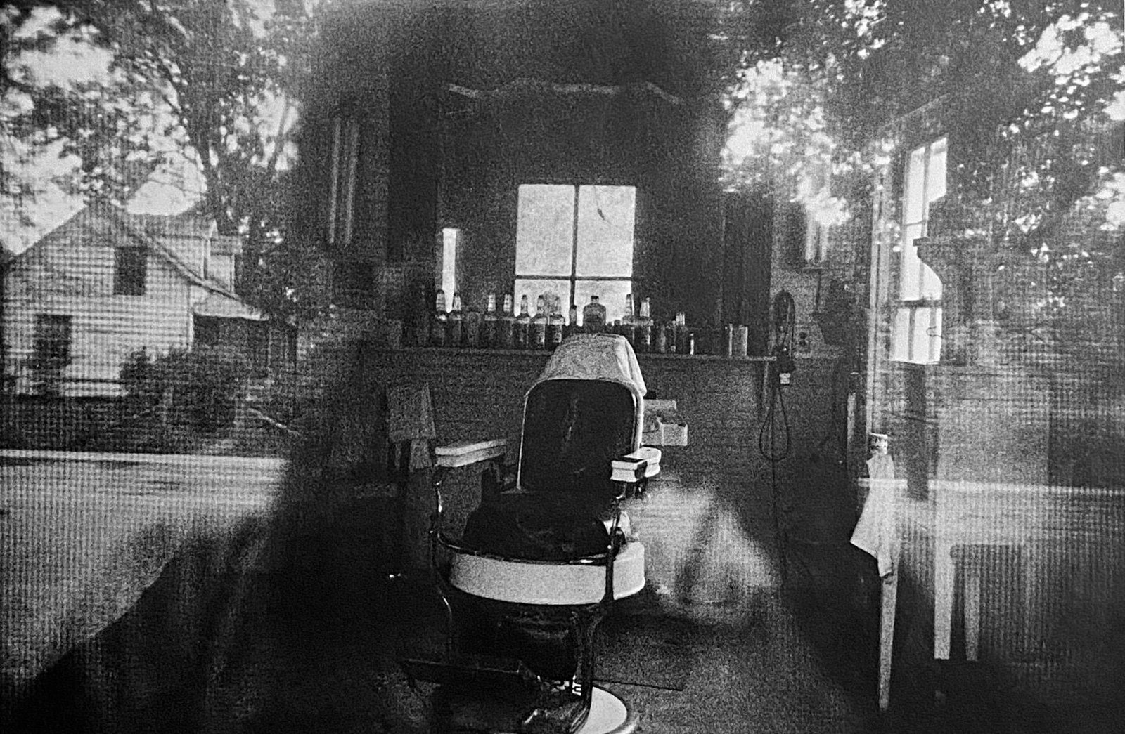 Robert Franks, Barbershop Through The Screen Door- McClellanville, South Carolina: Photographer: Robert Frank (1924-2019) was a Swiss photographer and documentary filmmaker, who became an American binational. His most notable work, the 1958 book titled The Americans, earned Frank co