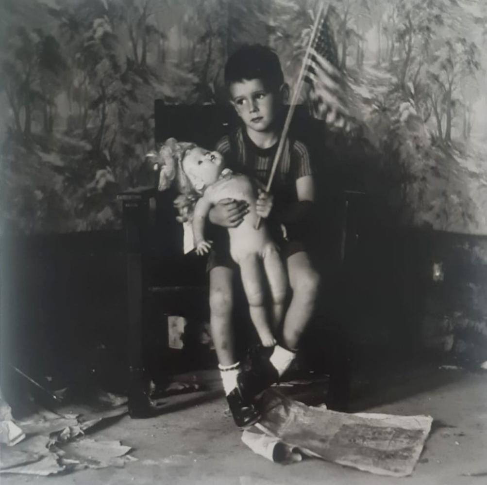 Ralph Eugene, Boy holding flag and doll, 1959: Photographer: Ralph Eugene Meatyard (May 15, 1925 - May 7, 1972) was an American photographer from Normal, Illinois, U.S. Meatyard purchased his first camera in 1950 to photograph his newborn first ch