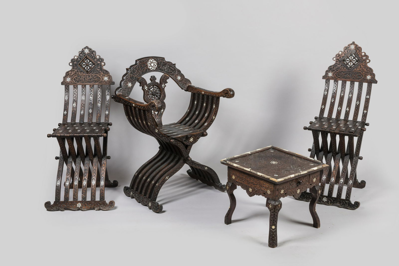 MOBILIER SALON: MOBILIER DE SALON SYRIEN en bois moulurÃ©, sculptÃ©, incrustÃ© de nacre et d'os Ã dÃ©cor d'arabesques et calligraphies pseudo-couffiques, comprenant une paire de chaises pliantes savonarole