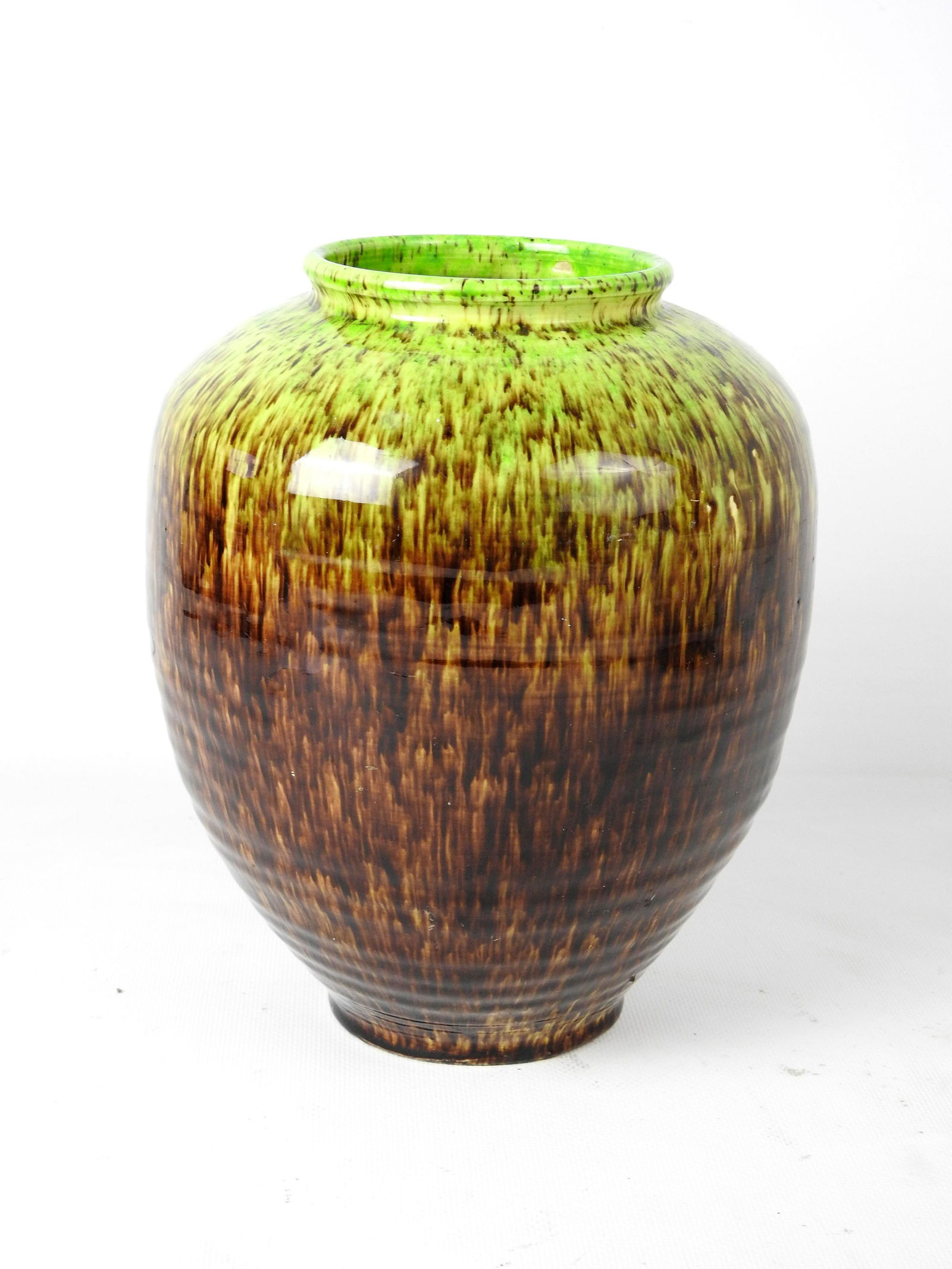 ACCOLAY: ACCOLAY Vase en ceramique mouchete brun sur fond vert anis, interieur jaune. Signe. Hauteur 26 - Largeur 20 cm