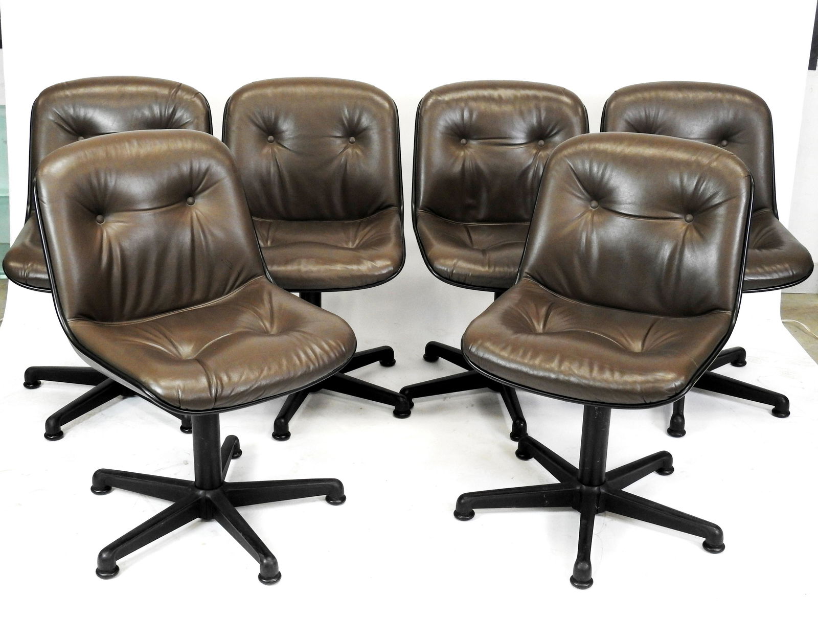 COMFORTO: COMFORTO eDITEUR - D'apres le modele " Executive chair " de Charles POLLOCK Six Chaises pivotantes de bureau a coques et pieds etoile en plastique noir. 81.5 x 51 x 46 cm (usures, assise griffee)
