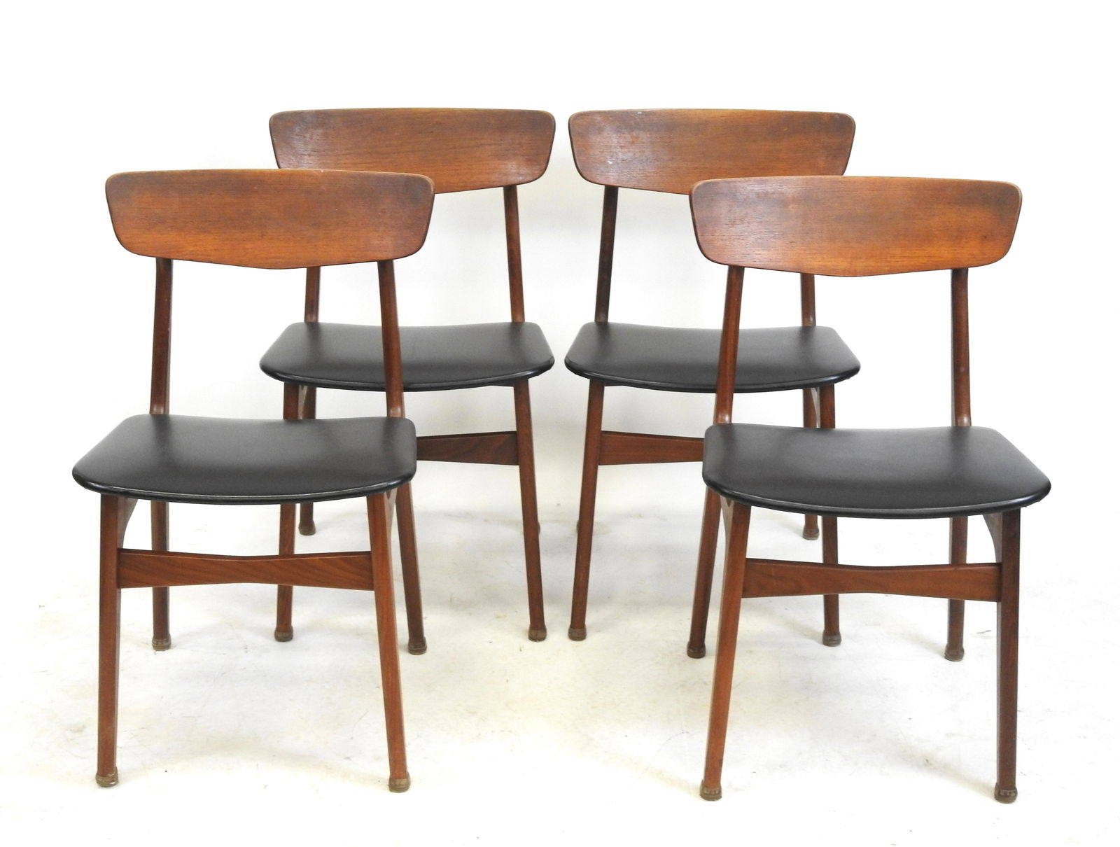 SCHIONNING ET ELGAARD: SCHIONNING & ELGAARD (XXe) dans le gout de: Quatre chaises en teck, le dossier en bandeau incurve, les garnitures en skaÃ¯ noir. Travail danois des annees 60. 78 x 46 x 45 cm. Quelques usures