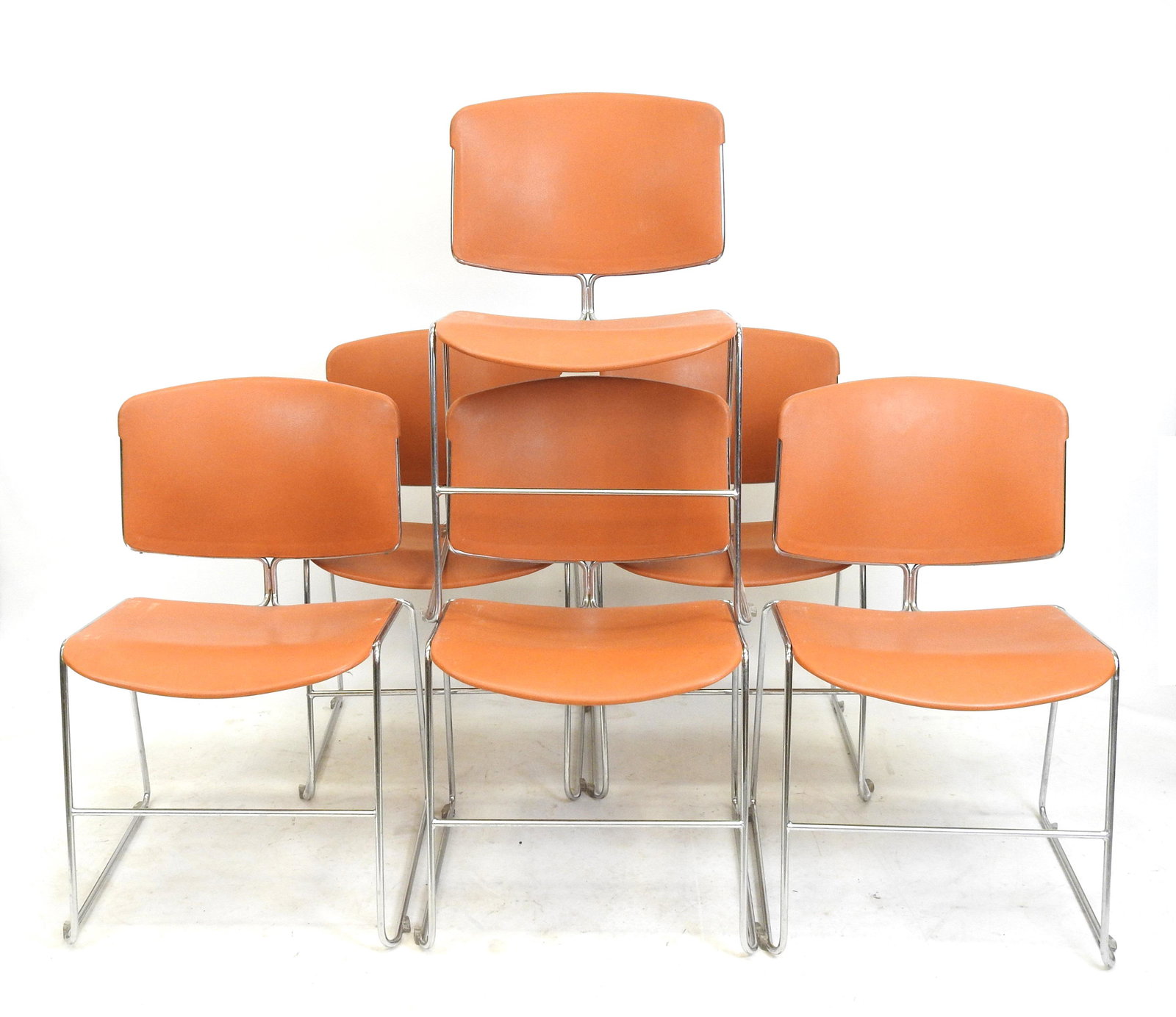MAX STACKER: Max STACKER (XX-XXI) pour Steelcase editeur: Six chaises empilables, structure en metal chrome, assise et dossier en matiere plastique thermoforme orange fauve. Annees 1970. Etiquettes anciennes sous