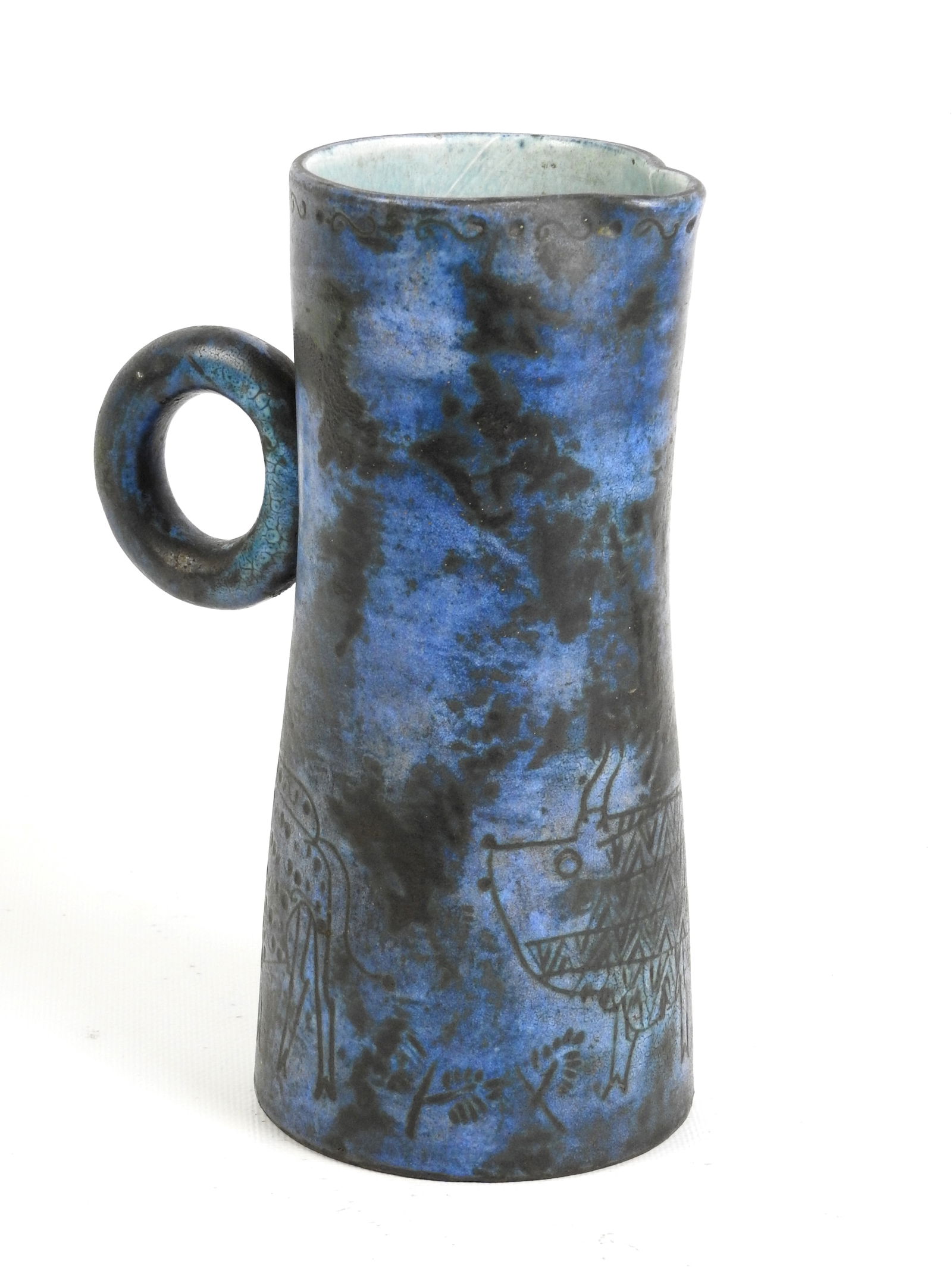 Jacques BLIN (1920 - 1995). Pichet a anse en emaillee bleu et noir a decor incise d une frise de: Jacques BLIN (1920 - 1995).Pichet a anse en emaillee bleu et noir a decor incise d une frise de personnages et animaux.Signe sous la base J Blin .Haut. : 25 cm.