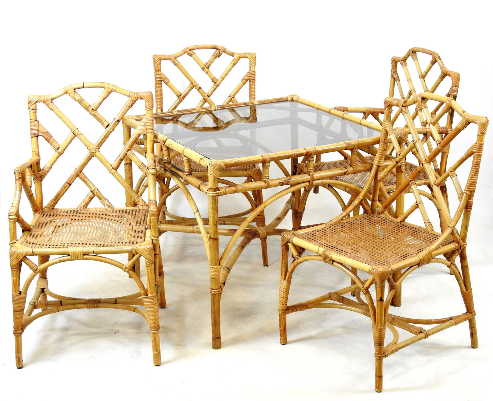 DAL VERA (editeur) : Ensemble de salon en rotin comprenant une table de section carre a plateau en: DAL VERA (editeur) : Ensemble de salon en rotin comprenant une table de section carre a plateau en verre fume, deux fauteuils, deux chaises. Annees 1970. Chaises: 93 x 0 x 46 cm. Fauteuils: 98 x 50 x