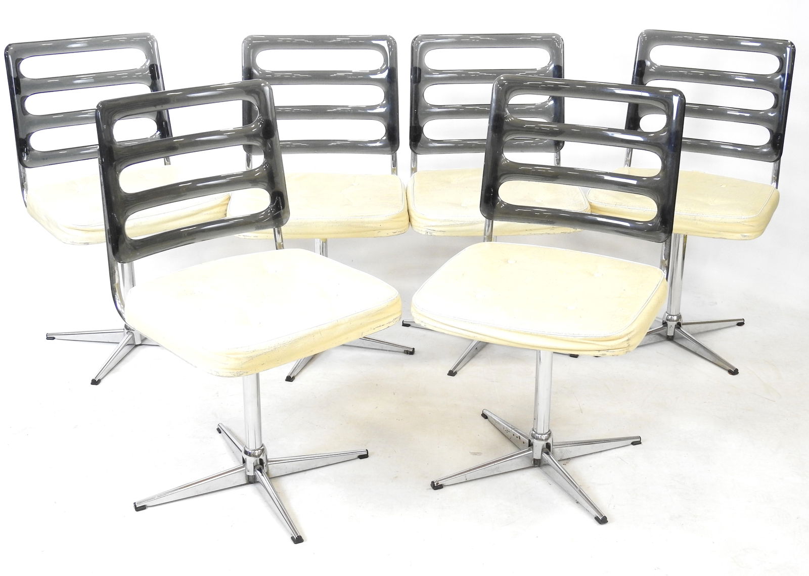 SIX CHAISES PIVOTANTES en metal chrome, dossier en plexiglas fume. Editeur presume Namco. Annees: SIX CHAISES PIVOTANTES en mÃ©tal chromÃ©, dossier en plexiglas fumÃ©. Editeur prÃ©sumÃ© Namco. AnnÃ©es 1970. H 81 L 45 P 47 cm. Usures Ã la garniture, traces de peinture sur deux chaise