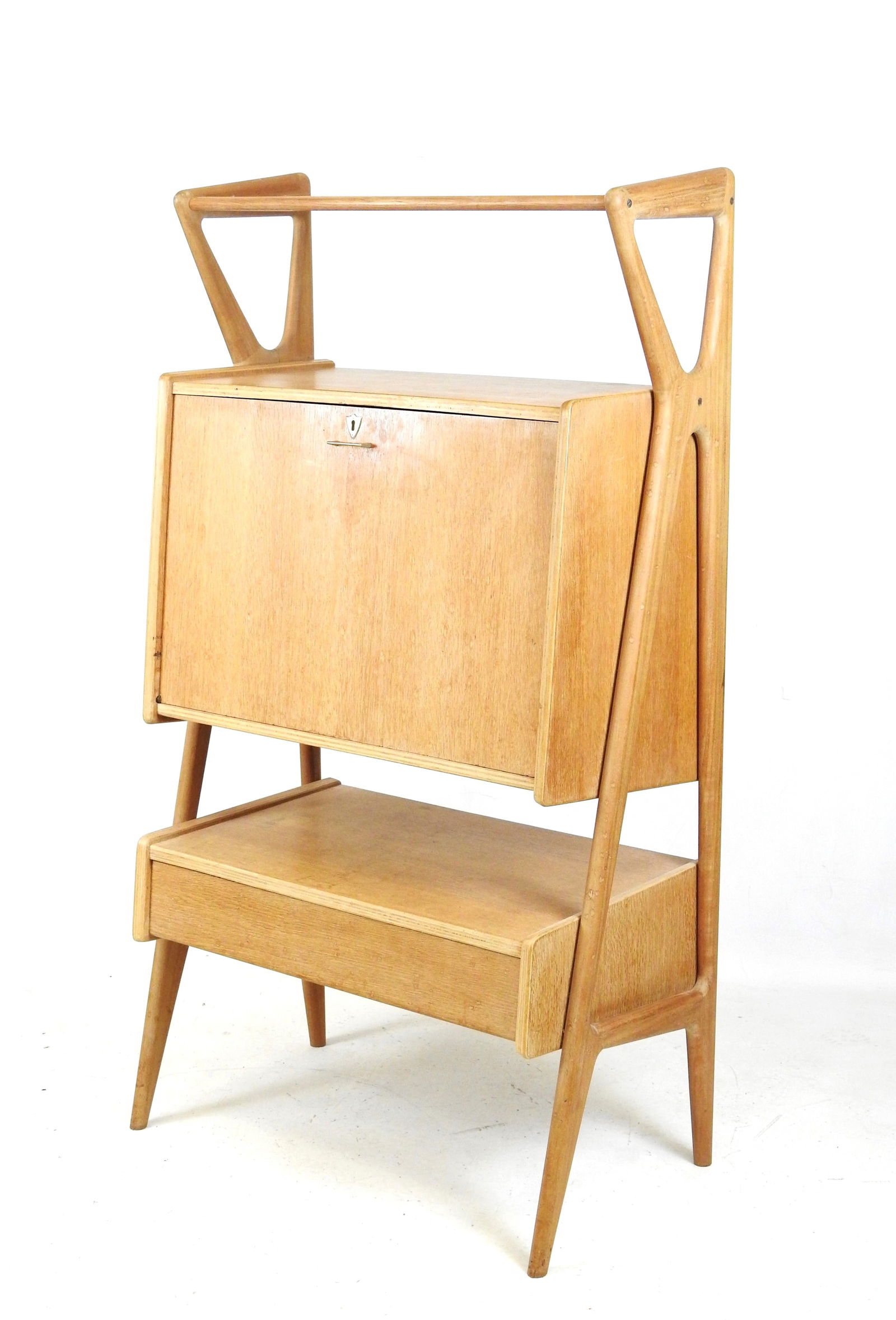 Louis PAOLOZZI (XXe): Secretaire en placage de chene ouvrant a un abattant et un tiroir en partie: Louis PAOLOZZI (XXe): Secretaire en placage de chene ouvrant a un abattant et un tiroir en partie basses, les montants et pieds compas. Annees 1950. H: 155 - L: 85 - P: 50 cm. Usures.