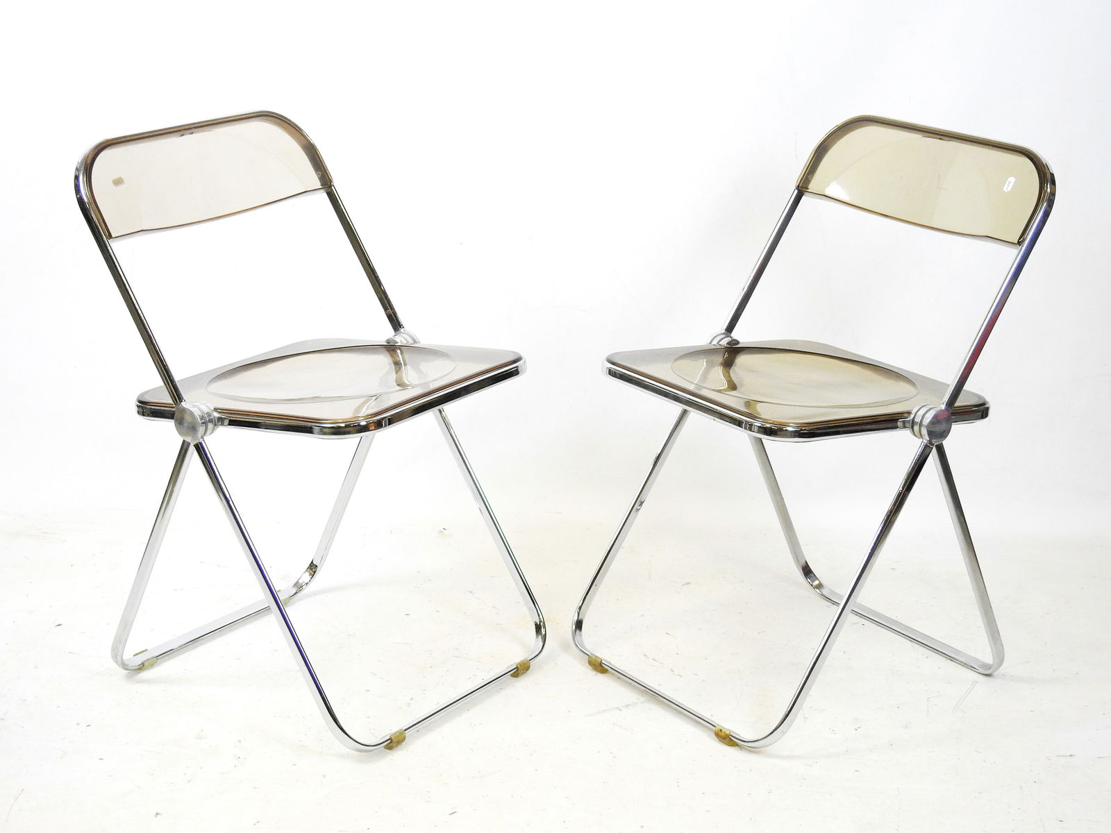 Giancarlo PIRETTI (ne en 1940) - Edition Castelli: Deux chaises pliantes, modele Plia, en metal: Giancarlo PIRETTI (ne en 1940) - Edition Castelli: Deux chaises pliantes, modele Plia, en metal chrome et plexiglas fume. H: 77 cm.