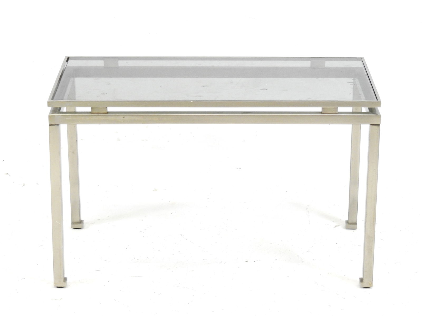 Guy LEFEVRE (1933-2018) pour la maison Jansen: Table basse bout de canape en metal brosse, plateau: Guy LEFEVRE (1933-2018) pour la maison Jansen: Table basse bout de canape en metal brosse, plateau de verre. Annee 1970. H 39 - L 61 - P 31 cm (usures)