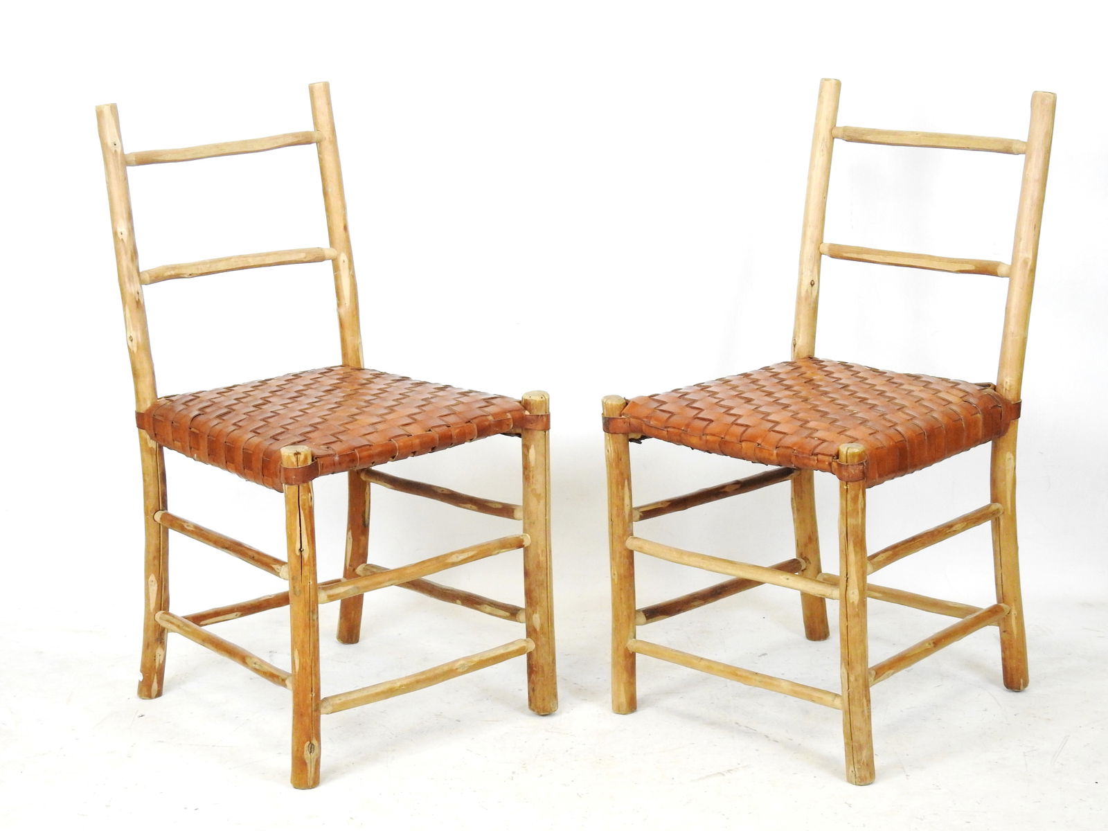 Lou FAGOTIN (editeur) : Paire de chaises en châtaignier et cuir tresse d'apres le modele de: Lou FAGOTIN (editeur) : Paire de chaises en châtaignier et cuir tresse d'apres le modele de fauteuil "Le Capitaine". H 88 - L :45 - P 45 cm. Il s'agit d'une commande speciale du restaurant L'hermitie