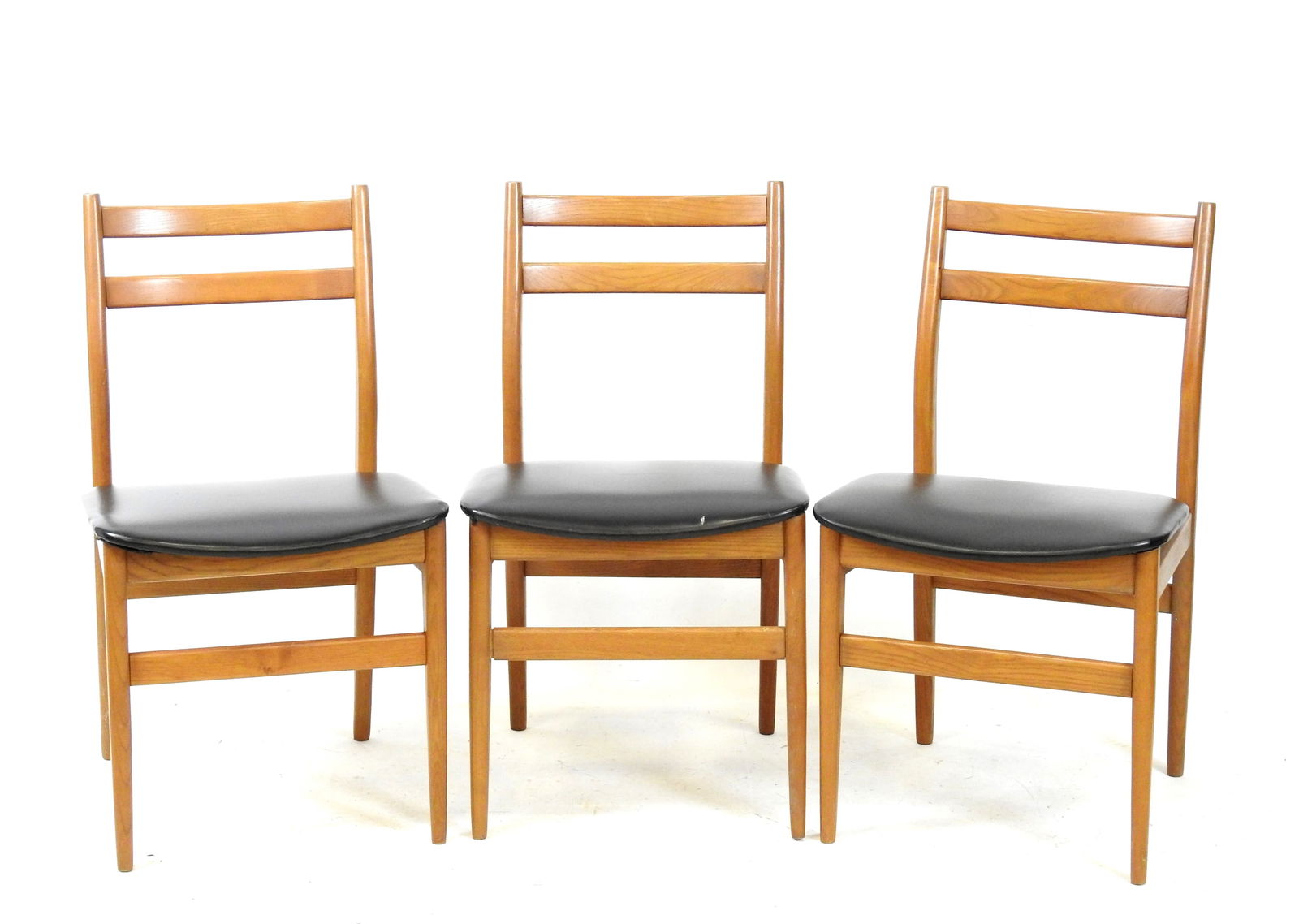 TROIS CHAISES en teck et skai noir. Travail scandinave. 82 x 47 x 47 cm (une dechirure sur une: TROIS CHAISES en teck et skai noir. Travail scandinave. 82 x 47 x 47 cm (une dechirure sur une assise)